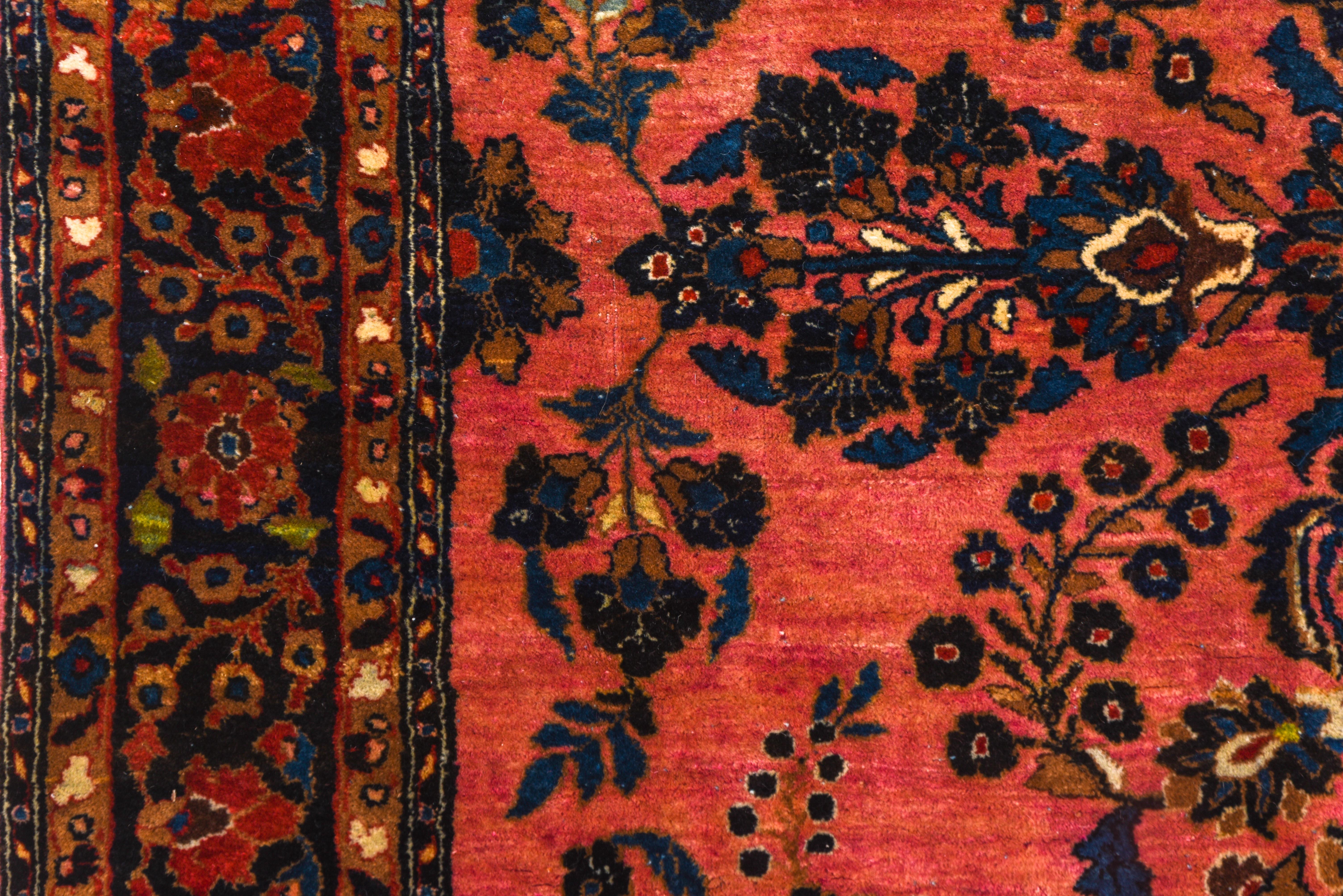 Début du 20ème siècle Tapis persan ancien Sarouk, terrain rose vif, bordures bleu marine, vers 9s0 en vente