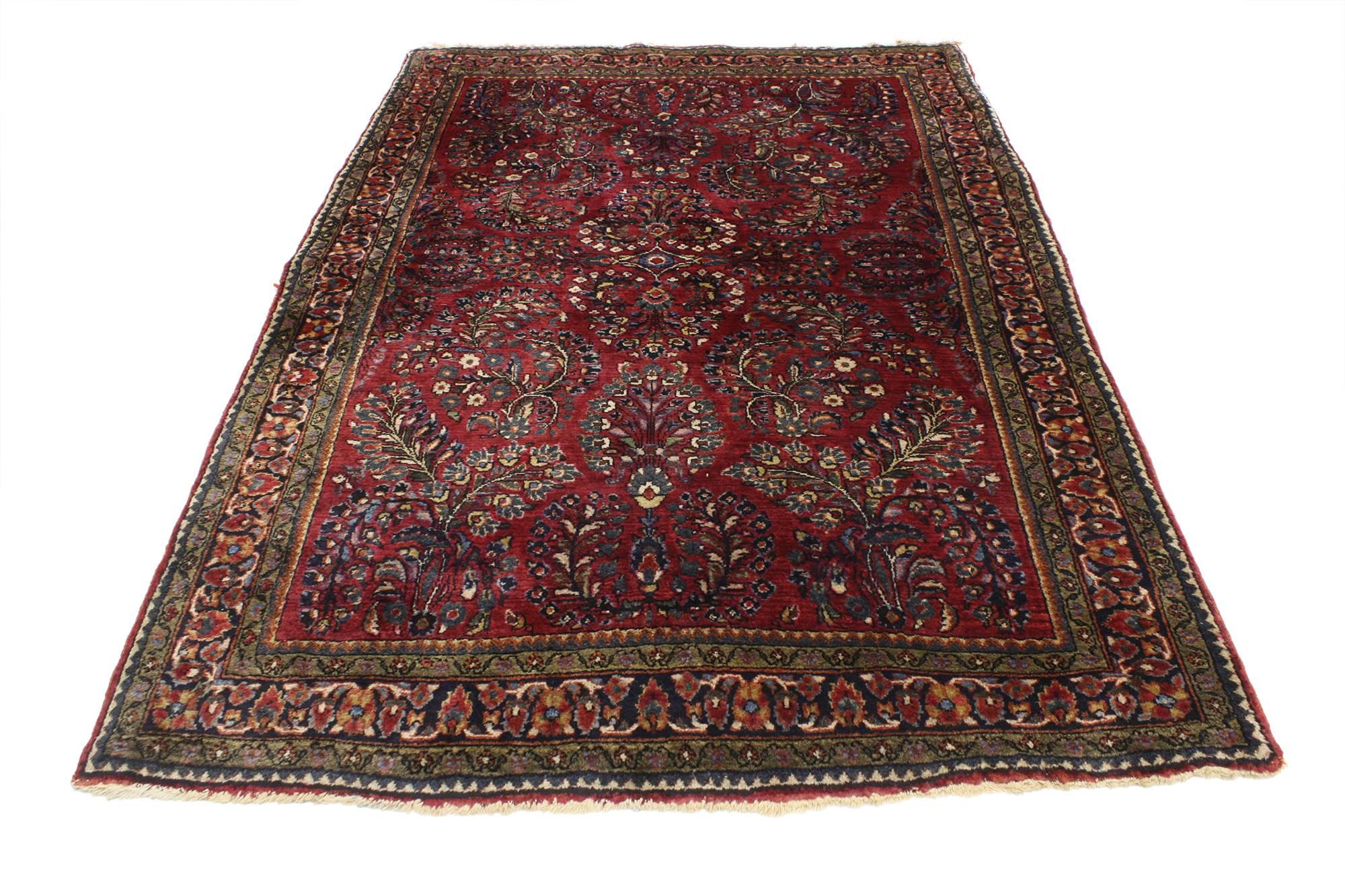 76947, antique Persian Sarouk rug with Art Nouveau style. Rich in color with beguiling beauty, this hand knotted wool antique Persian Sarouk rug is poised to impress. The abrashed dark ruby red field features an all-over botanical garden scene