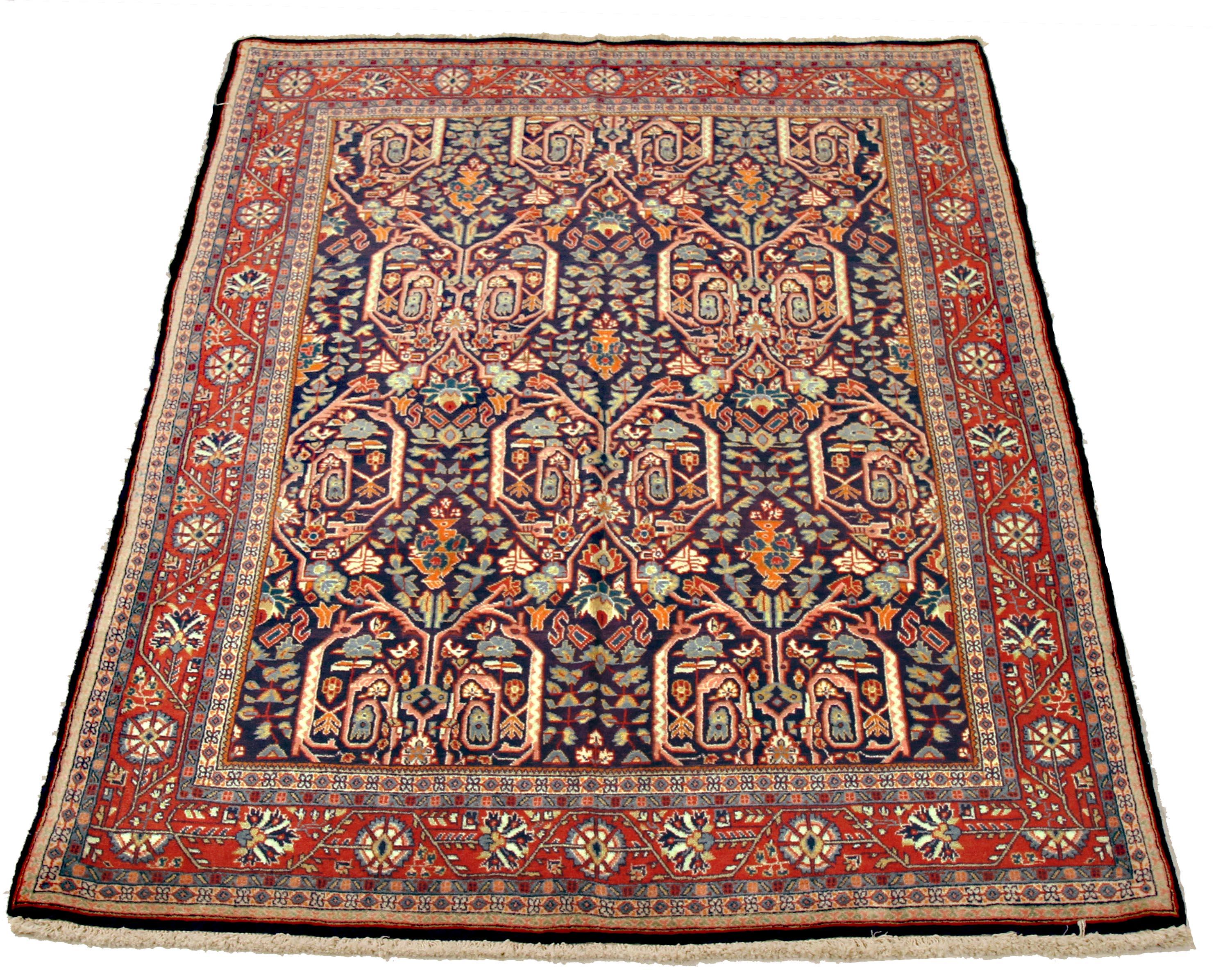 Antique Persian rug handwoven from the finest sheep’s wool and colored with all-natural vegetable dyes that are safe for humans and pets. It’s a traditional Sarouk design featuring colored botanical details. It has a rich navy blue center field with