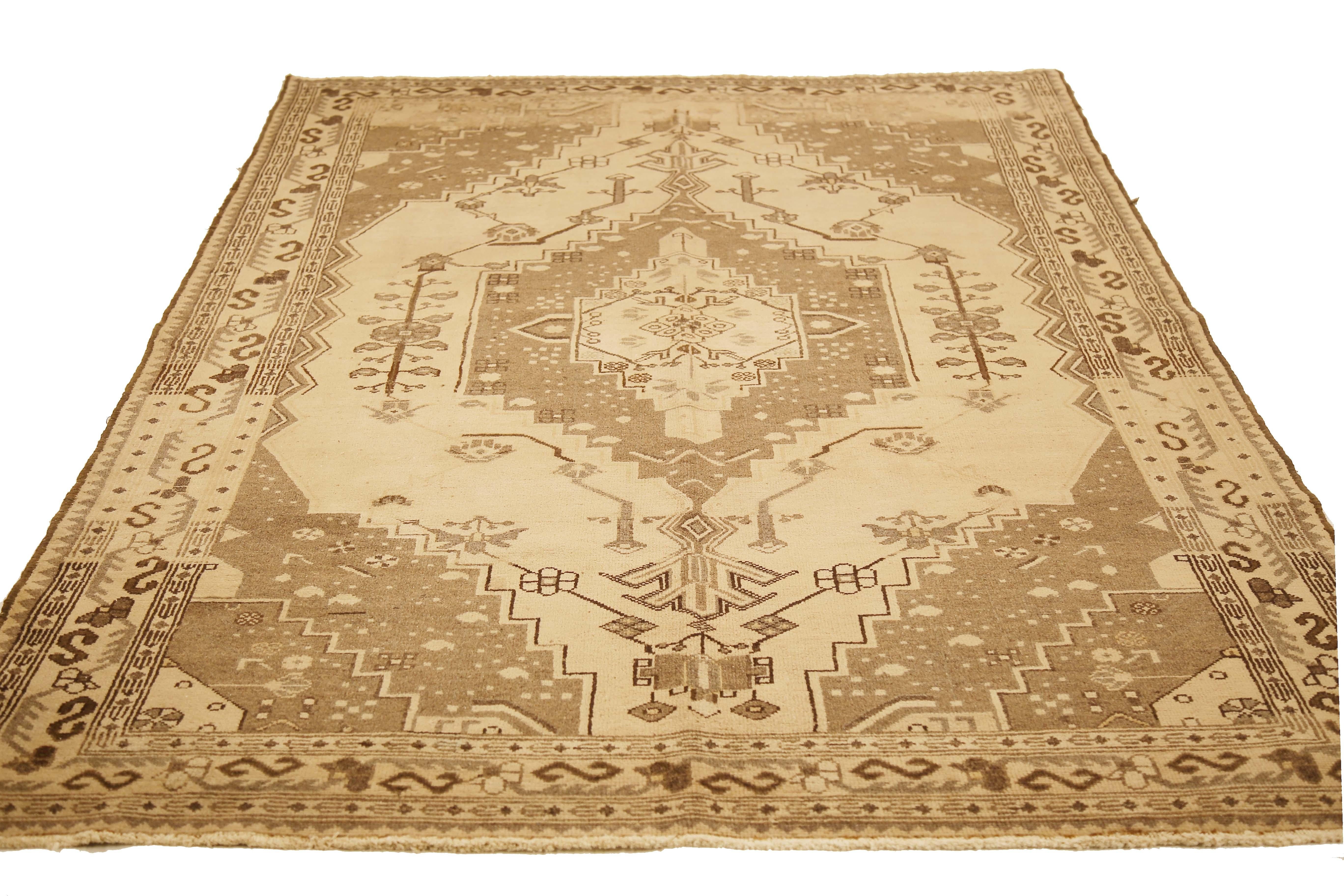 Antique Persian rug handwoven from the finest sheep’s wool and colored with all-natural vegetable dyes that are safe for humans and pets. It’s a traditional Saveh design highlighted by a large gray and brown botanical medallion on its center field.