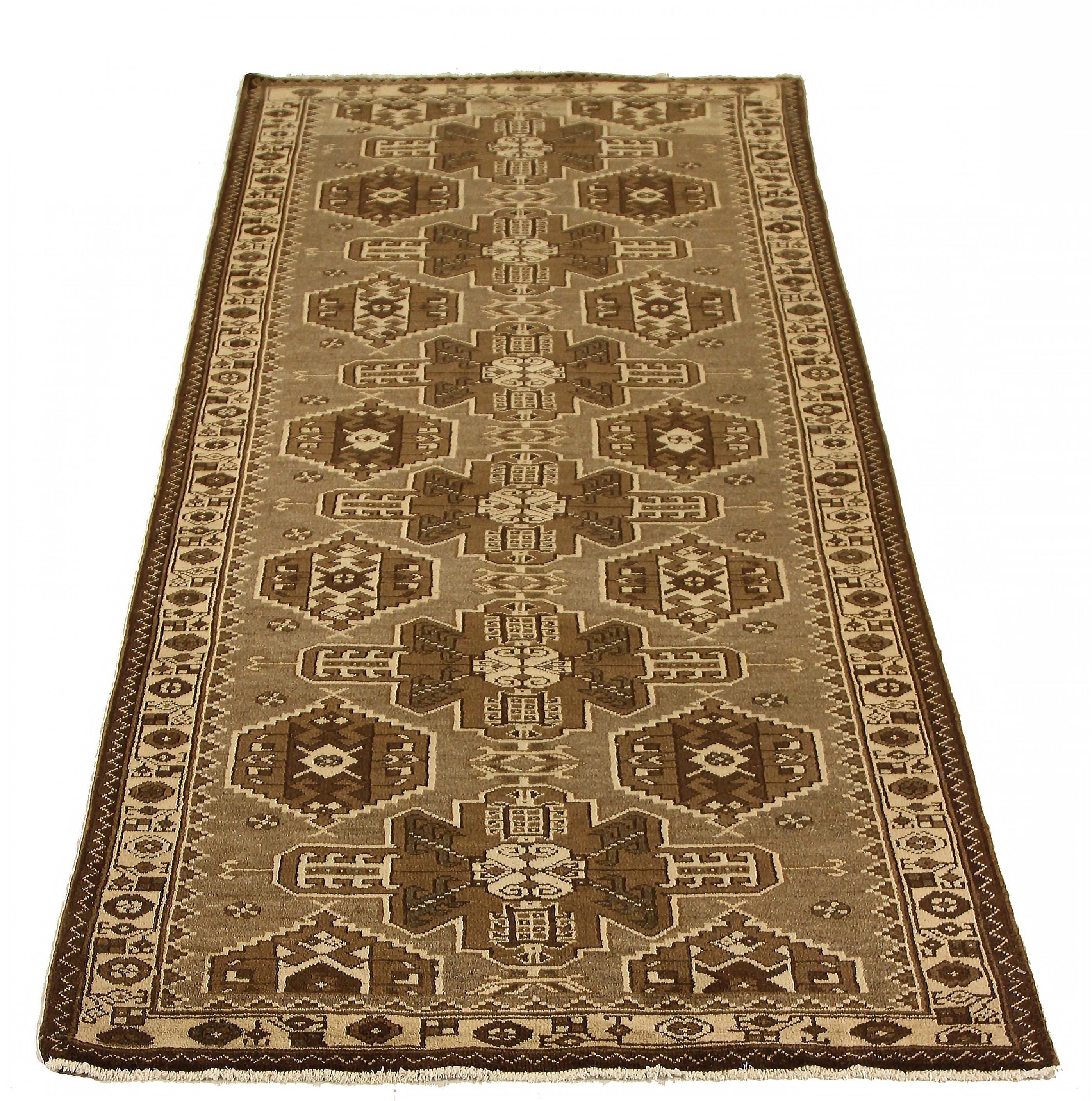 Antique Persian area rug handwoven from the finest sheep’s wool. It’s colored with all-natural vegetable dyes that are safe for humans and pets. It’s a traditional Saveh design featuring botanical details on a beige and brown field. It’s a lovely