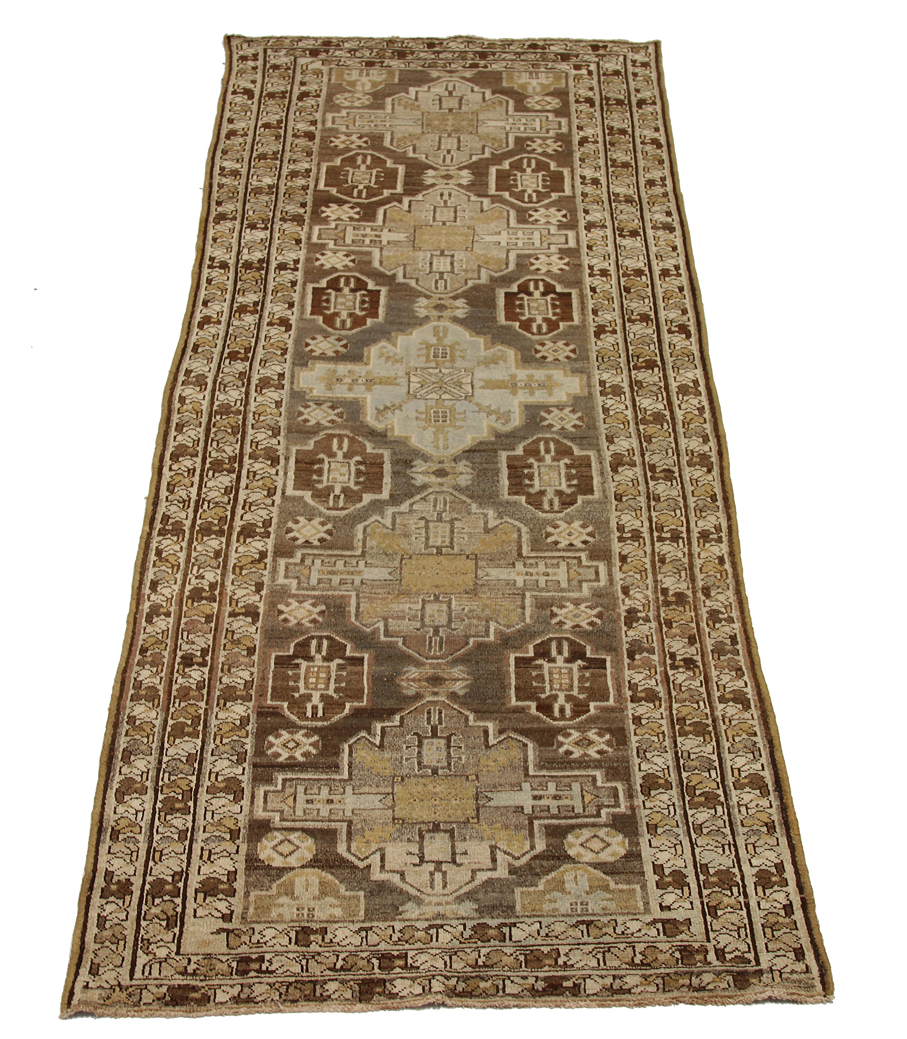 Antique Persian runner rug handwoven from the finest sheep’s wool. It’s colored with all-natural vegetable dyes that are safe for humans and pets. It’s a traditional Saveh design featuring geometric and tribal designs on a brown field. It’s a lovely