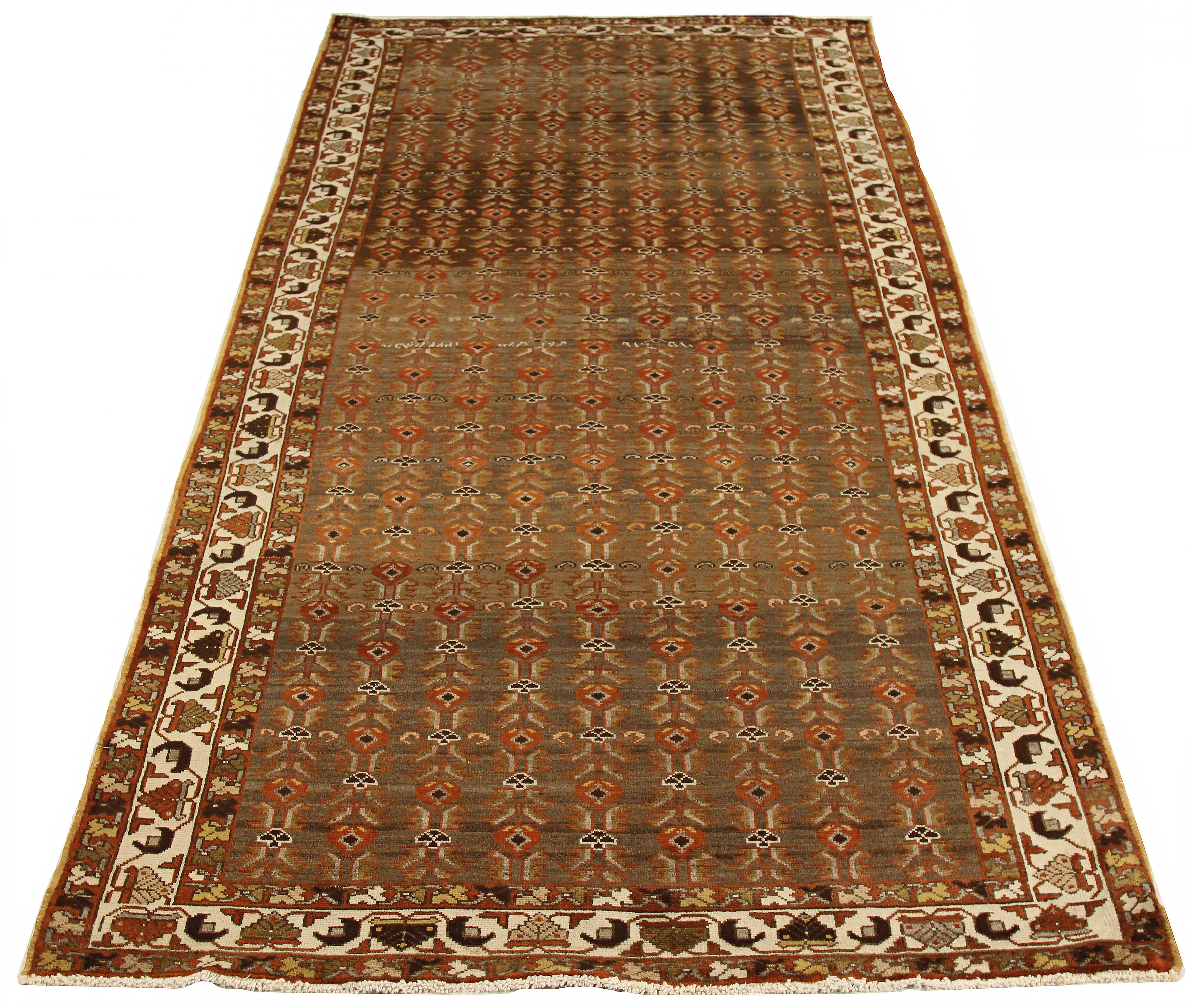 Antique Persian area rug handwoven from the finest sheep’s wool. It’s colored with all-natural vegetable dyes that are safe for humans and pets. It’s a traditional Saveh design featuring botanical details on a red and brown field. It’s a lovely