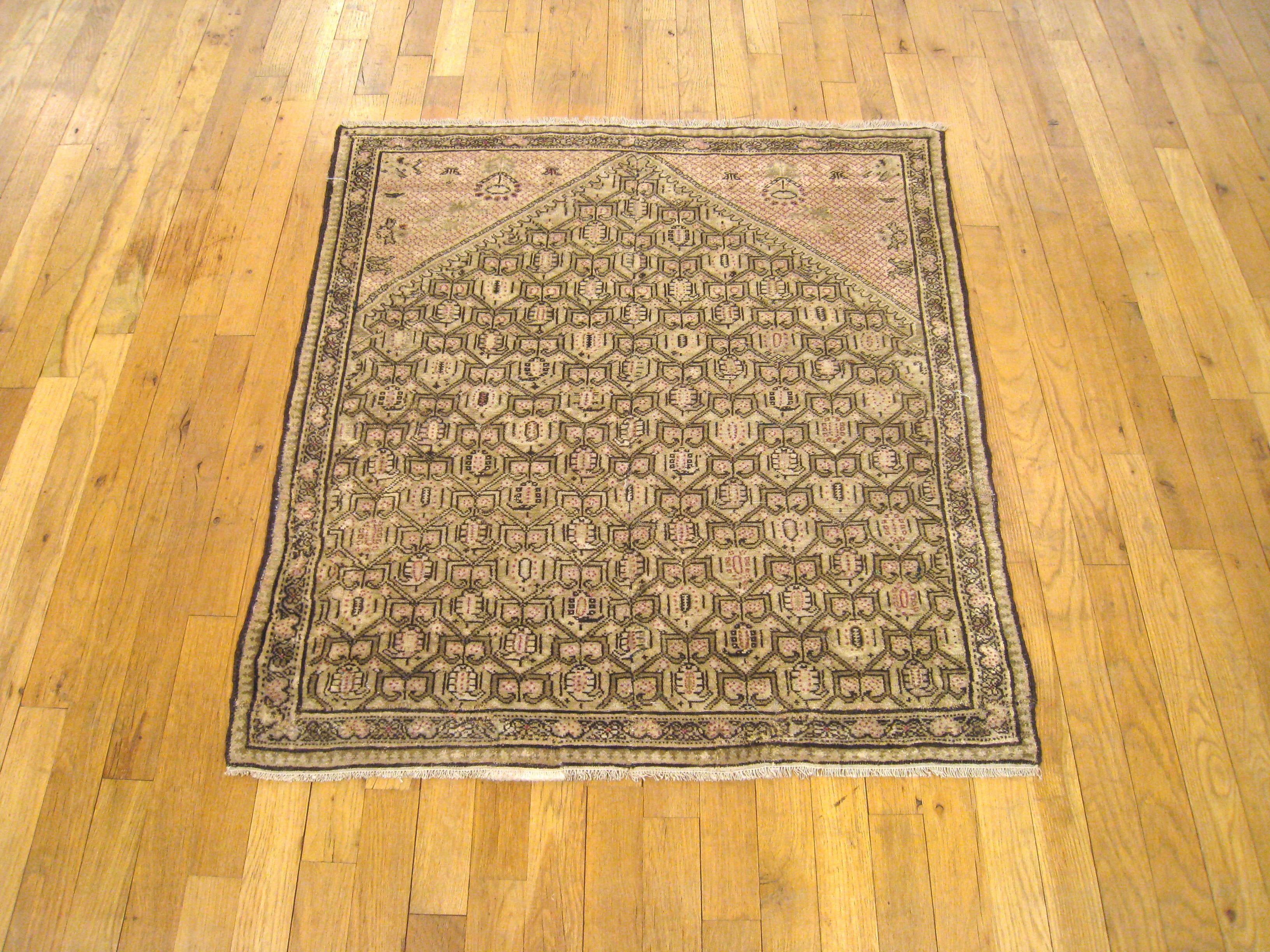 An antique Persian Seneh Oriental rug, circa 1900, size 3'3 x 3'0. This handsome collectible carpet features a stylized repeating design covering the soft earth tone field, with sparsely decorated camel colored swaths at the upper corners. Composed