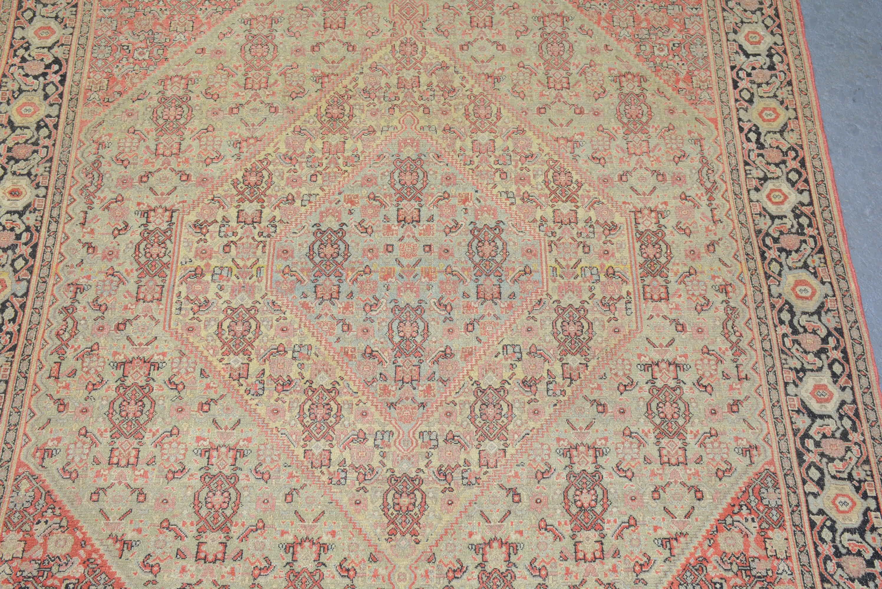 Un tapis antique Senna du nord-ouest de la Perse, présentant une série de médaillons hexagonaux en escalier dans une palette de couleurs naturelles et pâles. Mesures : 6' 4