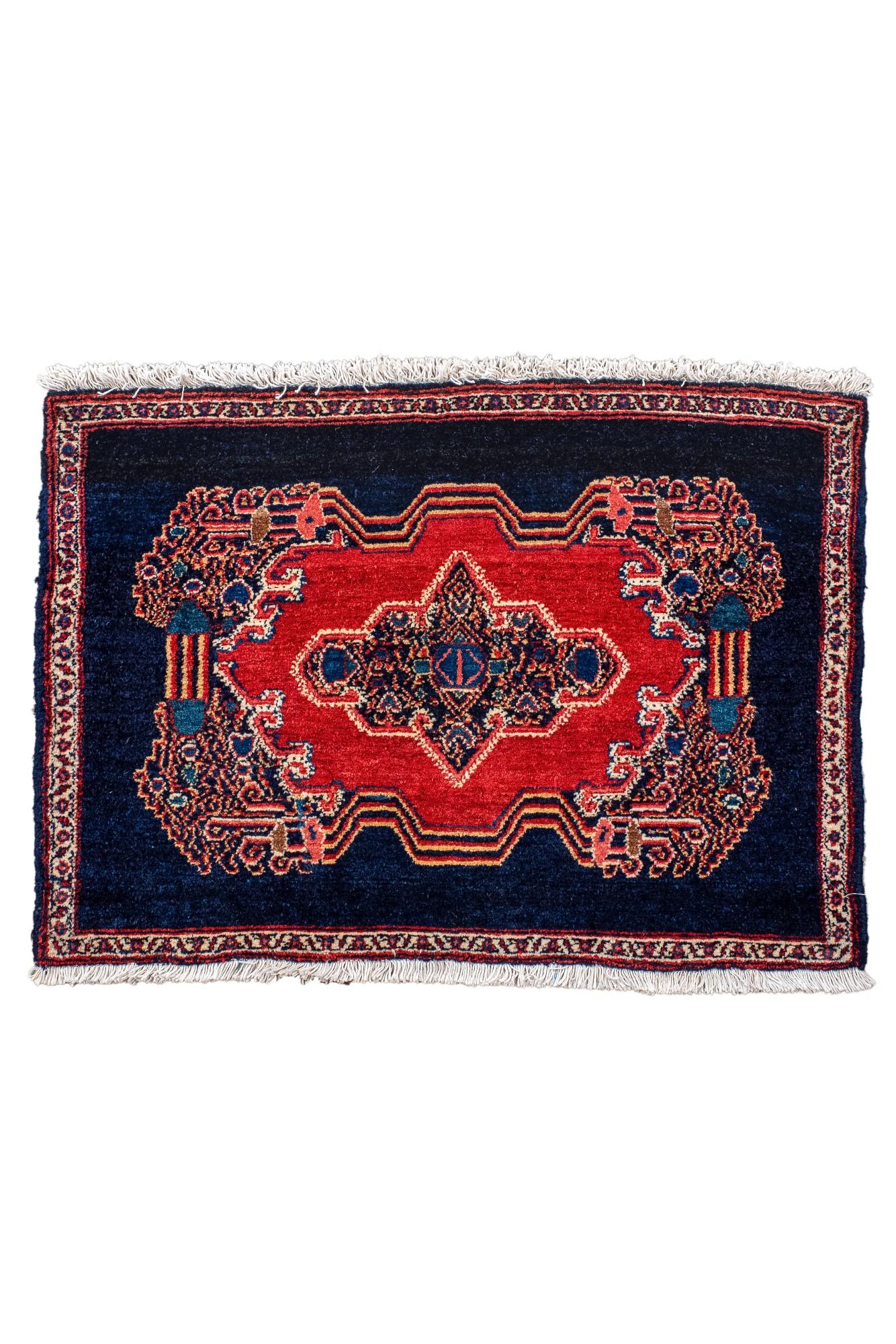 Dieser antike persische Senneh-Teppich, der um 1930 gewebt wurde, zeigt ein auffallend rotes
Medaillon in einem tief indigoblauen Feld mit komplizierten floralen und geometrischen Details. Seine
Durch seine geringe Größe eignet er sich ideal als