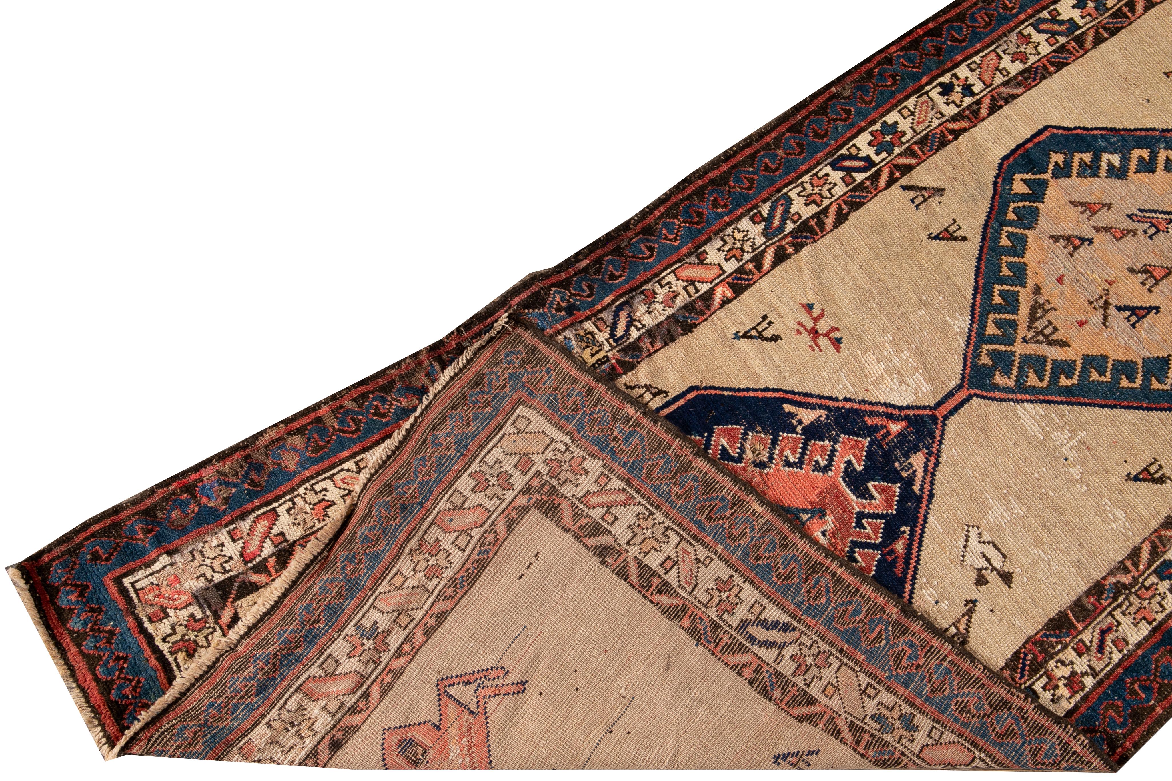 Beautiful antique Serab hand-knotted wool rug with a beige field. This Persian rug has a navy-blue frame and brown, rust, and peach accents in a gorgeous all-over geometric medallion design.

This rug measures: 2'10