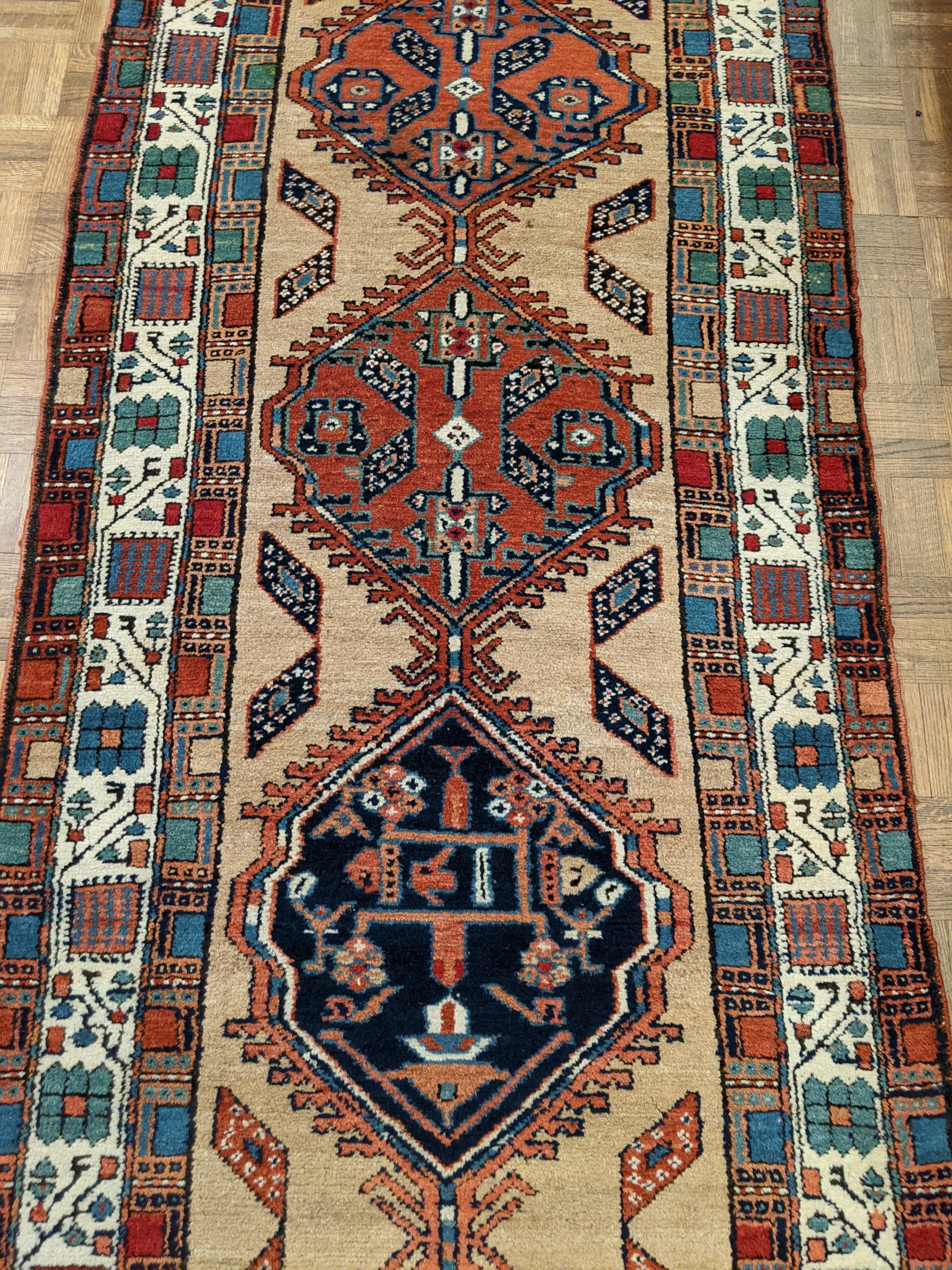 This is a striking antique Persian Serab. Serab rugs are known for their geometric design as well as the use of camel color. The typical Serab motif with the use of a cinnamon rust color is accented on the camel field. This rug is 3-1x12-6 and is