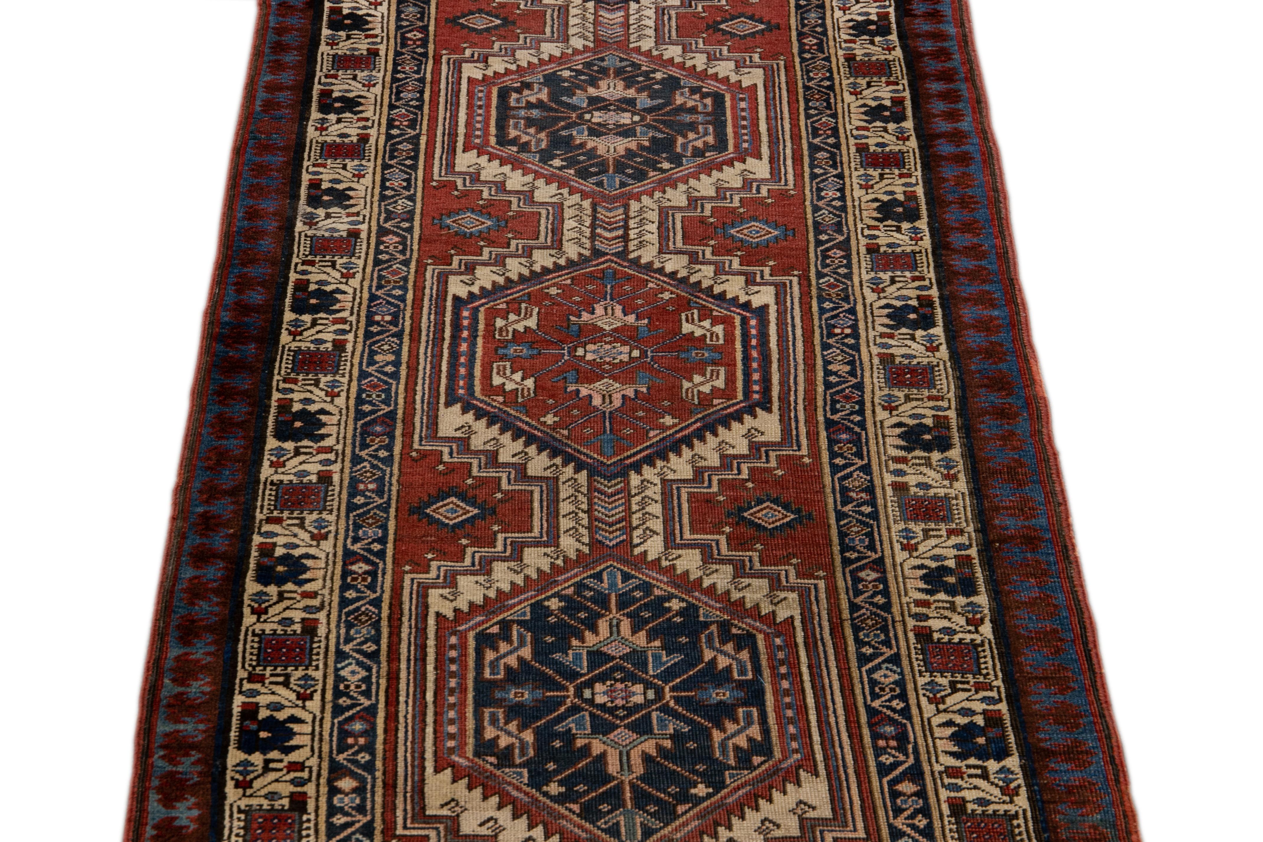 Beautiful antique Serab hand-knotted wool runner with a rust field. This Persian rug has a beige frame and multicolor accents in a gorgeous all-over geometric tribal design.

This rug measures: 3'3