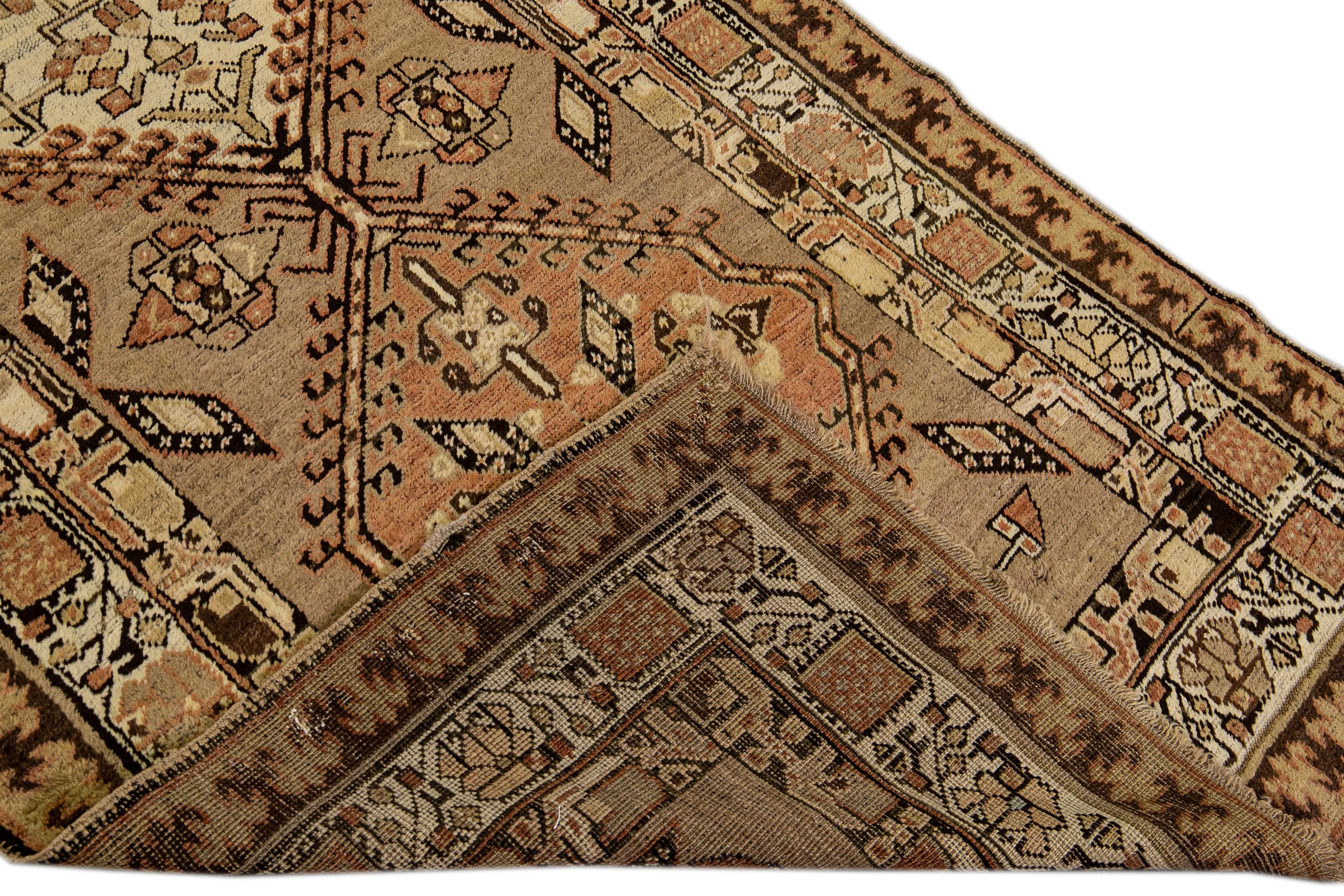Beautiful antique Serab hand-knotted wool runner with a tan field. This Persian rug has a beige and brown accent in an all-over tribal design. 

This rug measures 3'10