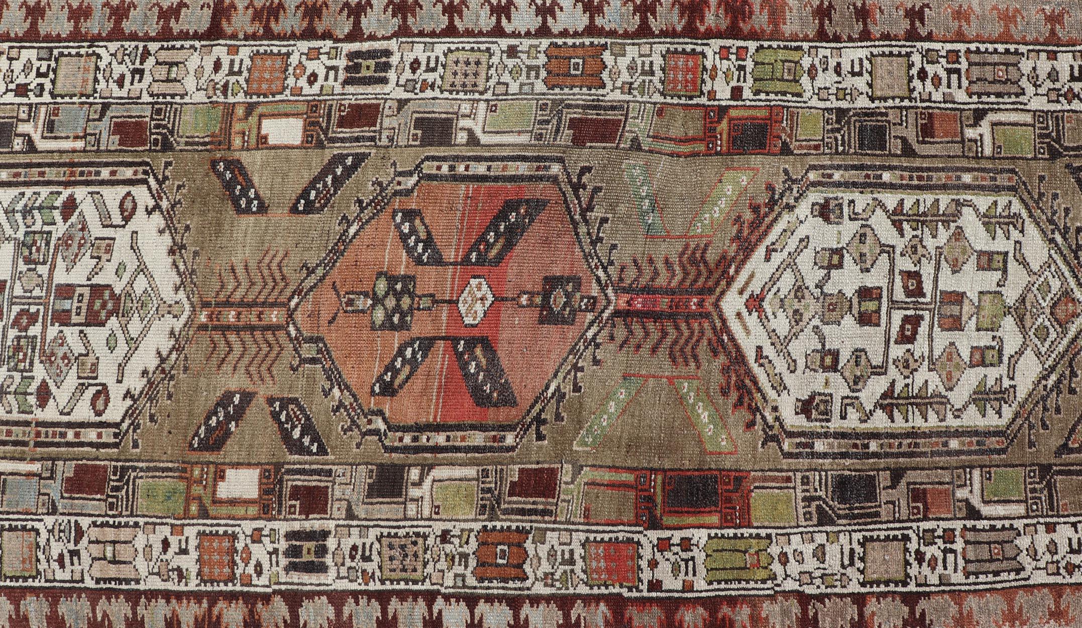 Misure: 3'4 x 17'0 
Antico runner persiano Serab con audaci medaglioni geometrici, 3'4 x 17'0. 
Keivan Woven Arts/ tappeto/N15-0501, paese d'origine/tipo: Iran / Serab, circa 1900.

Questo sorprendente runner antico persiano Serab presenta una serie