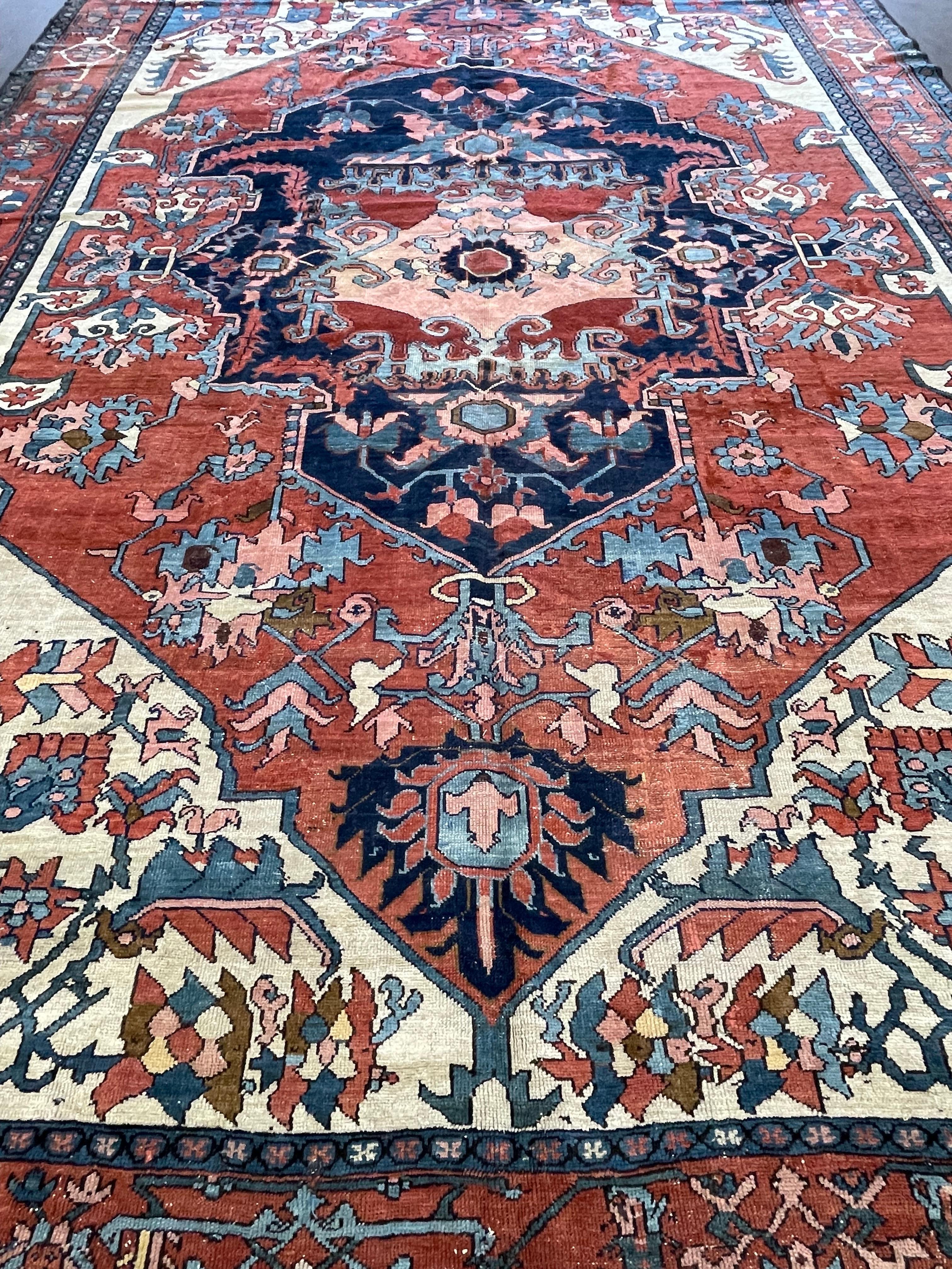 This magnificent carpet is handwoven in the northwest region of Persia in the town of Heriz/Serapi. Serapi carpets structure consist of a single cotton warp and double cotton weft and knots are Turkish.

The huge off center medallion in indigo