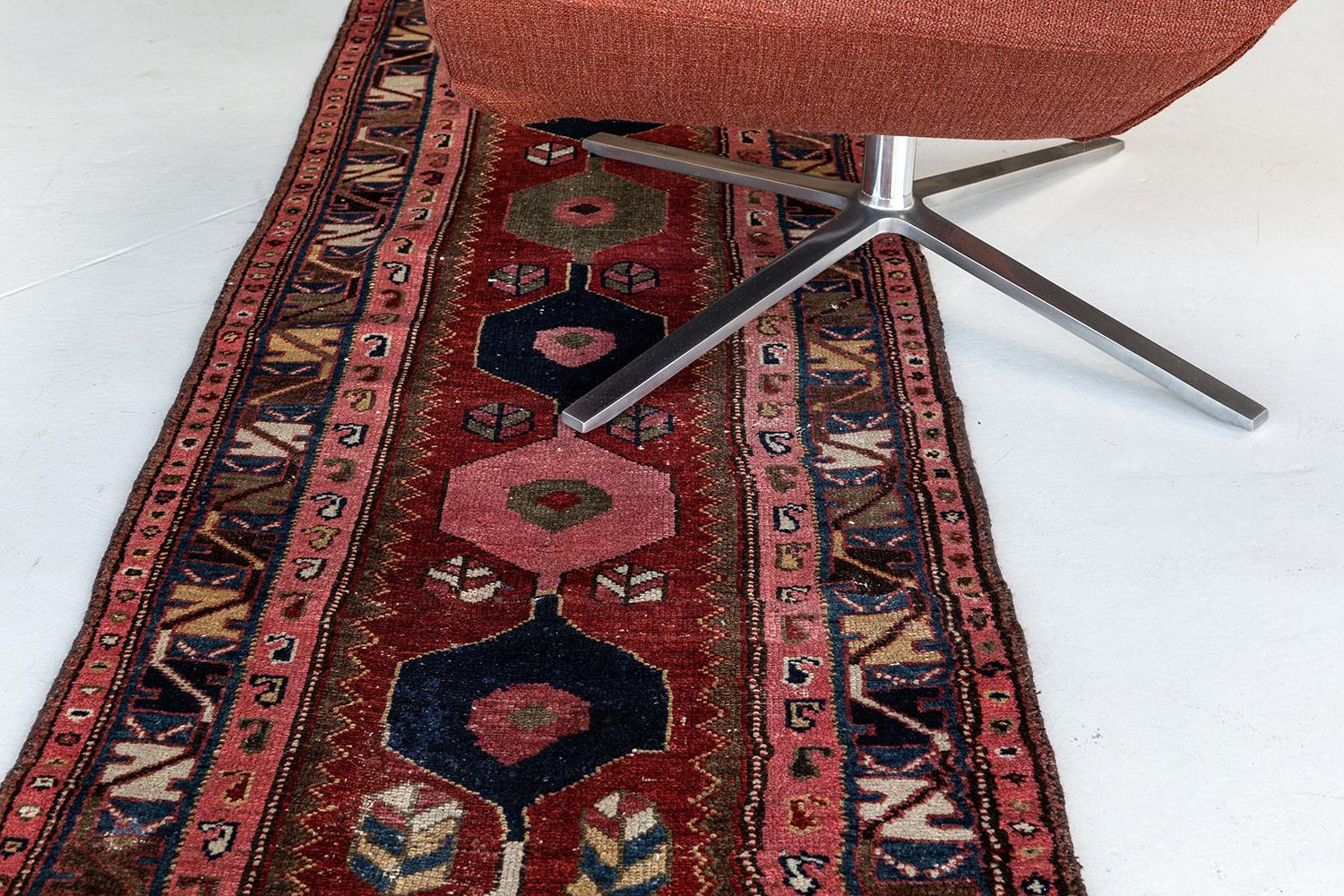 Exuding exquisite grace and majestic architectural design elements, this lovingly time-worn Antique Persian Serapi Runner can elegantly blend with modern, contemporary and traditional interiors. It features alternating series of hexagonal medallions