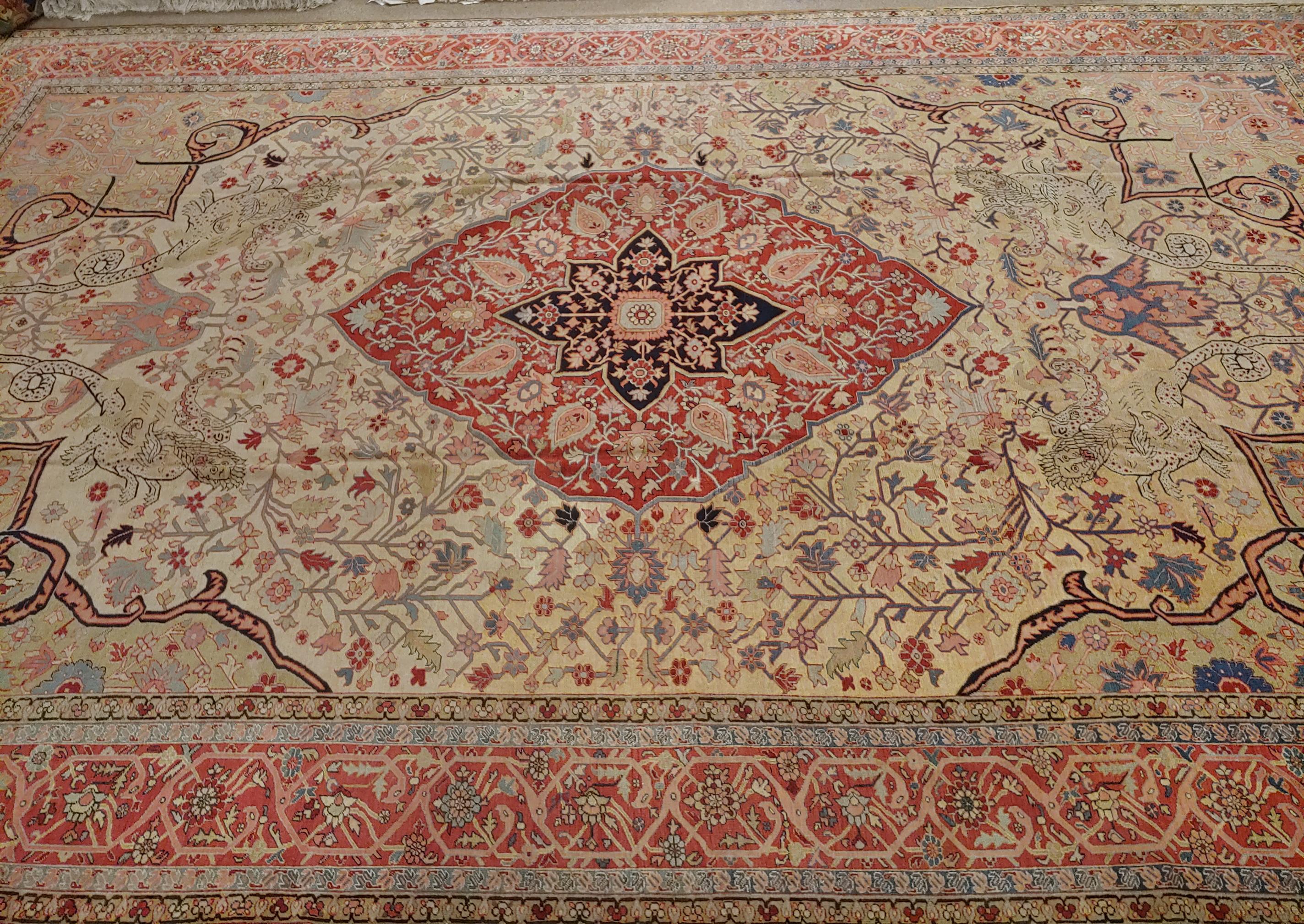 This is a rare antique Persian Serapi. While it appears to have a traditional motif, part of the field designs depicts four mythalogical dragons or snakes with the face of humans this is a very decorative rug with great colors. It is 12-3 x 19-3,