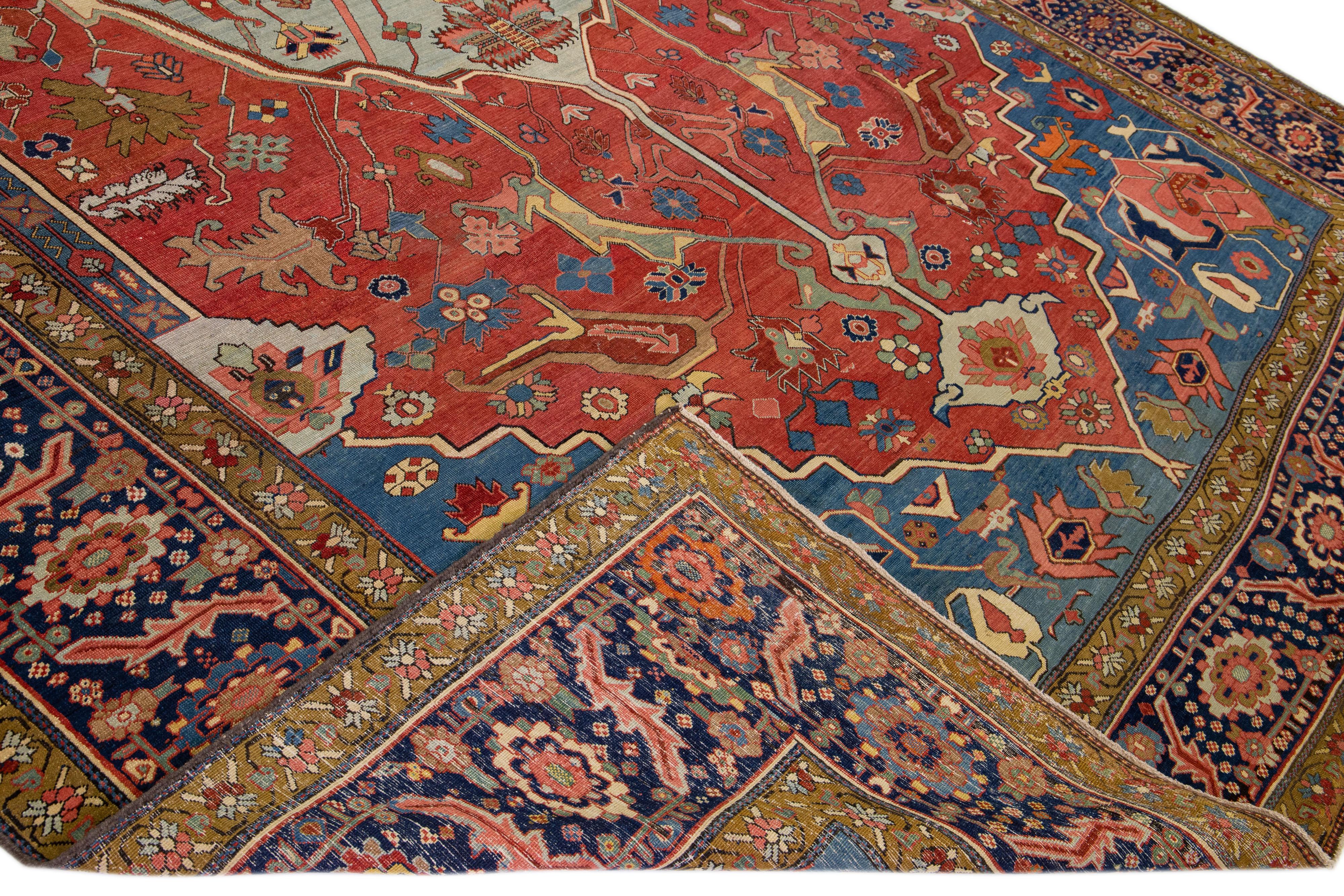 Schöne antike Serapi handgeknüpfte Wolle Teppich mit einem roten und roten Feld. Dieser Perserteppich hat mehrfarbige Akzente, die ein wunderschönes geometrisches, florales Medaillonmuster zeigen.

Dieser Teppich misst: 11'8
