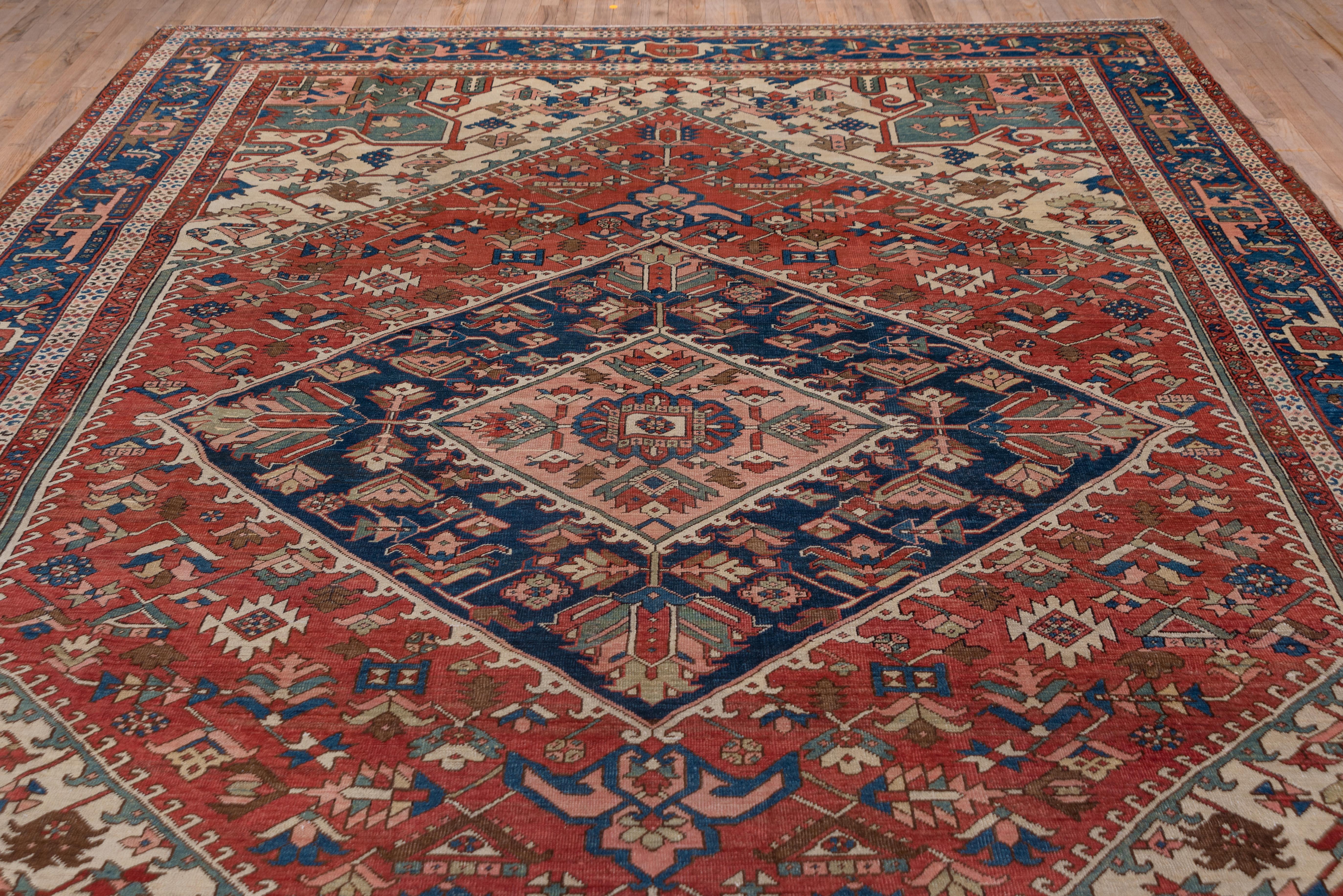 Early 20th Century Antique Persian Serapi Rug, Rust Field, Blue Borders, Pink and Green Accents For Sale