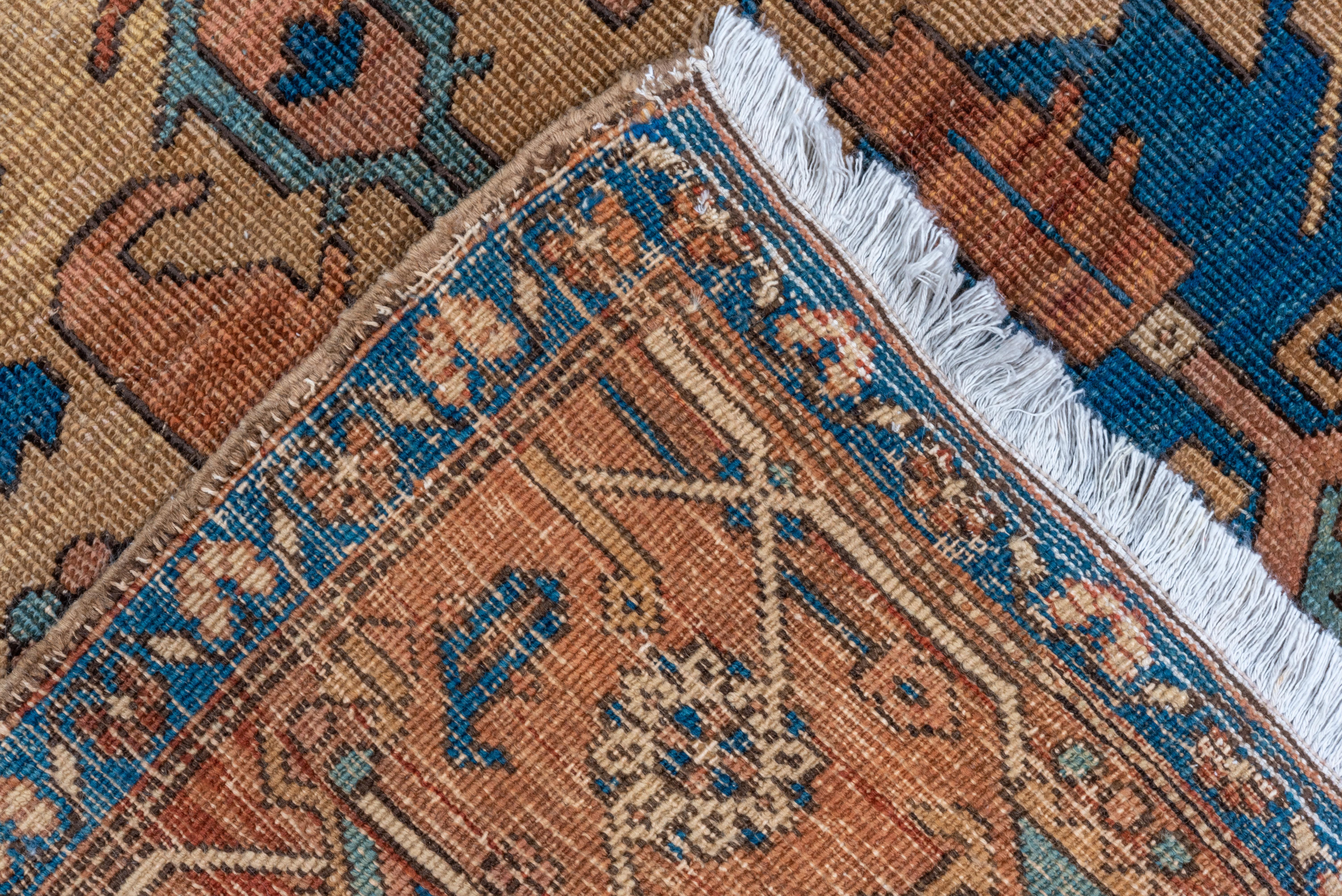 Early 20th Century Antique Persian Serapi Rug, Tan All-Over Field, Rust Borders, Royal Blue Accents For Sale