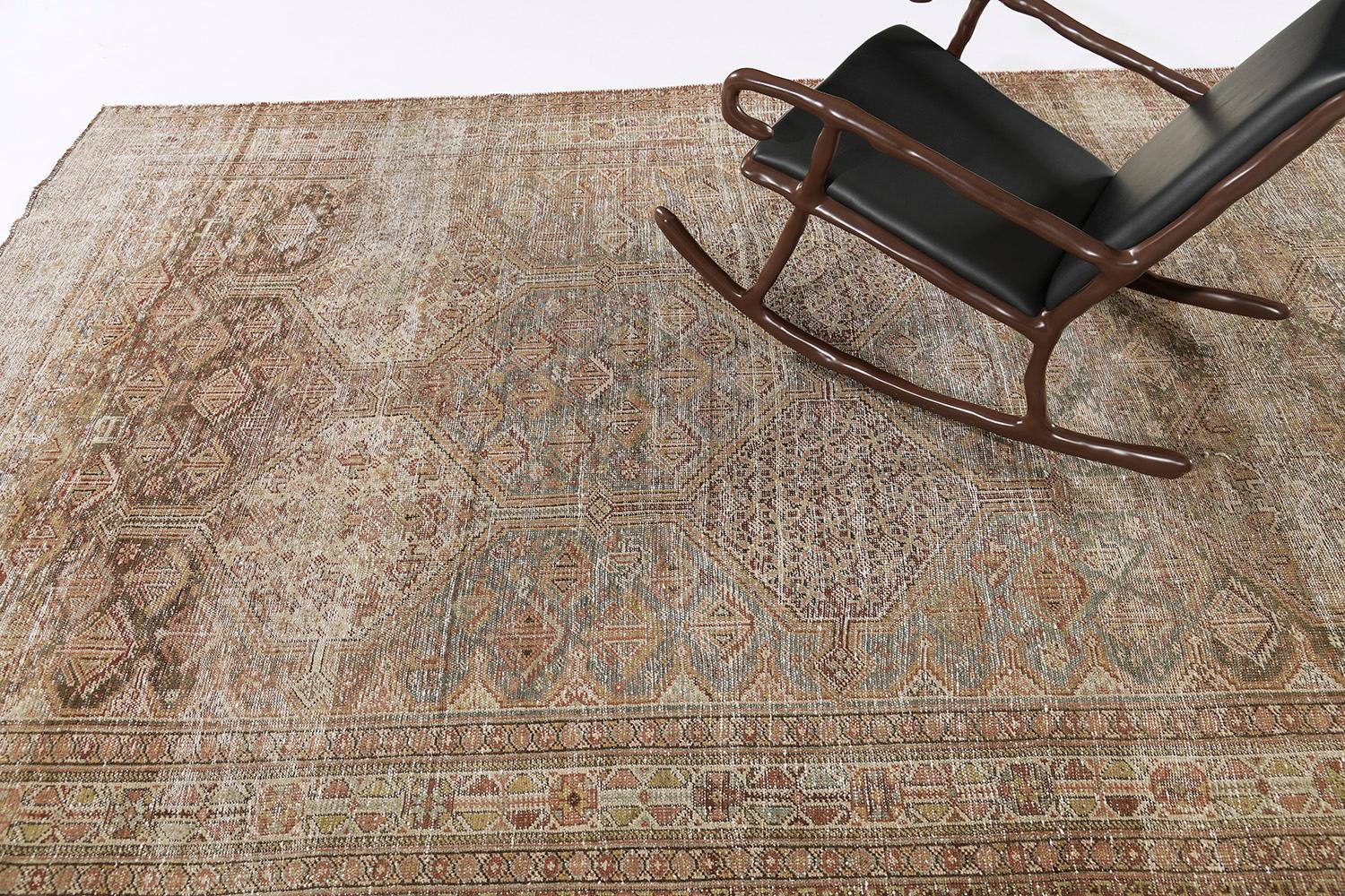 This antique Persian Shiraz rug features a phenomenal geometric panel design in alternating symbolical patterns. Tones of pleasant earthy colours of warm tan and pale gold predominate all over this compelling work of art. Perfect to wide range of