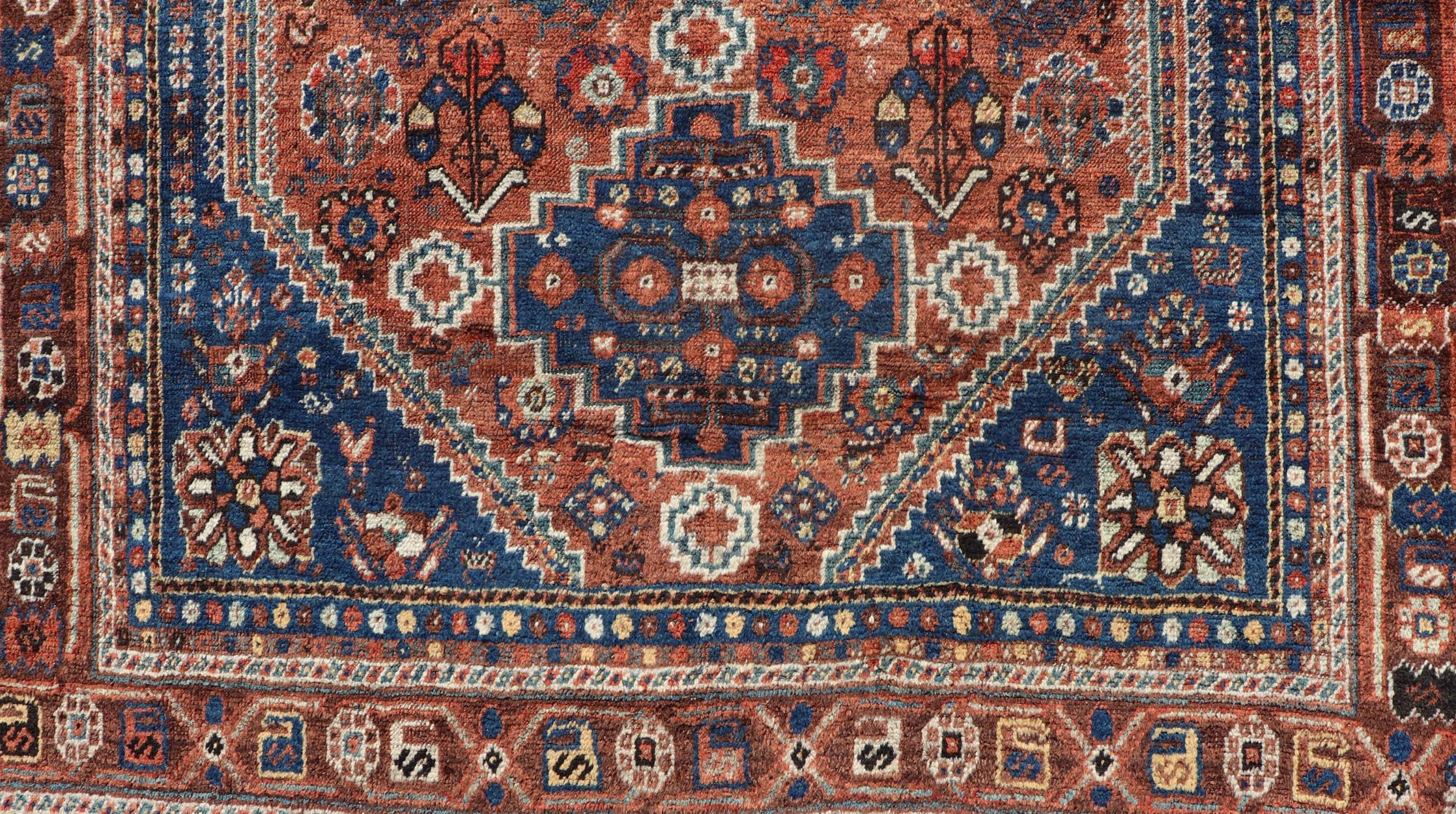 Persian Shiraz antique rug in blue and brunt orange with Medallion geometric design, Keivan Woven Arts / rug EMB-9706-P13456, country of origin / type: Iran / Shiraz, circa 1920.

Measures: 5'2 x 6'10.