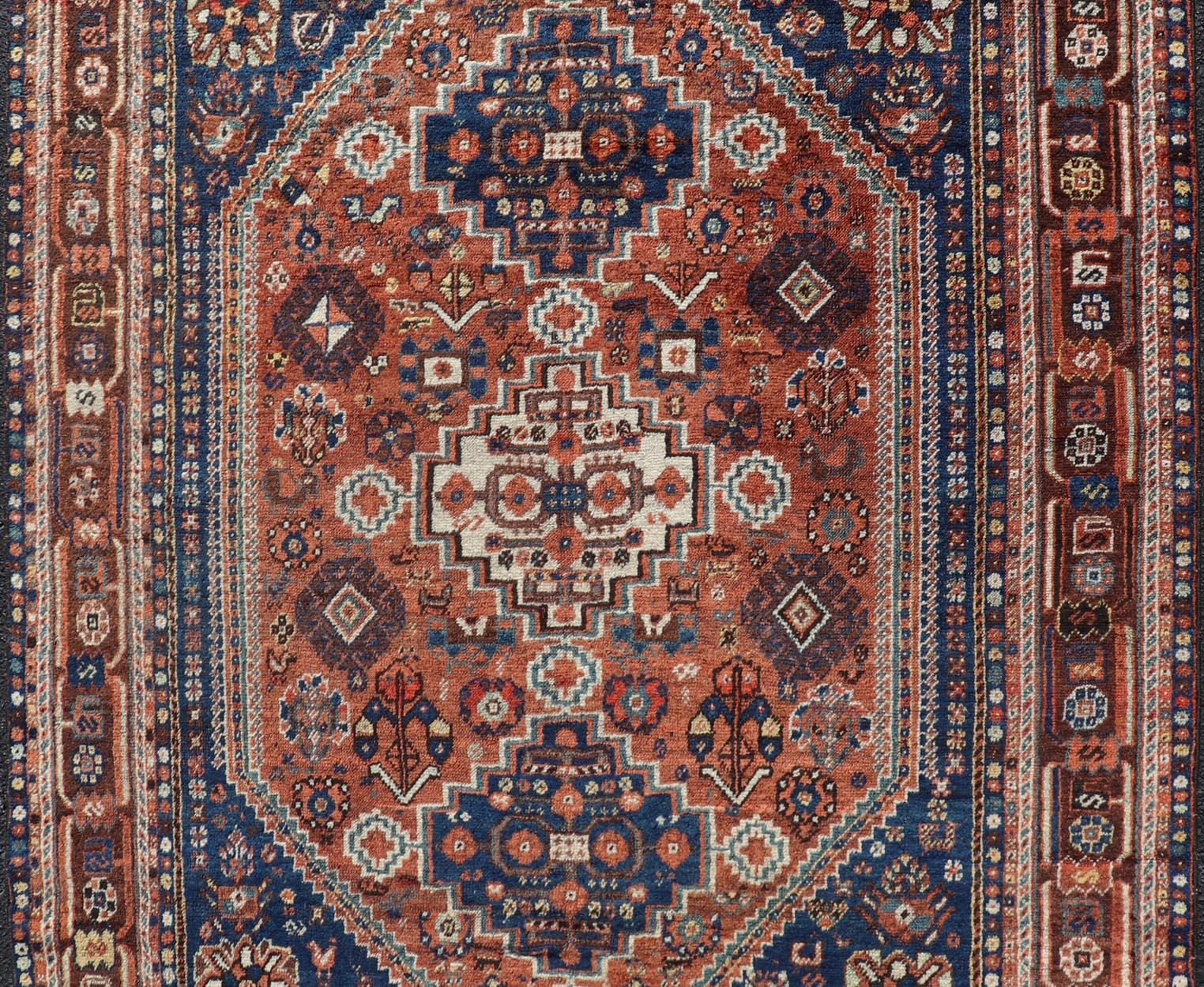 XX secolo Tappeto antico persiano Shiraz con geometrie a tre medaglioni in arancione e blu arrugginito in vendita
