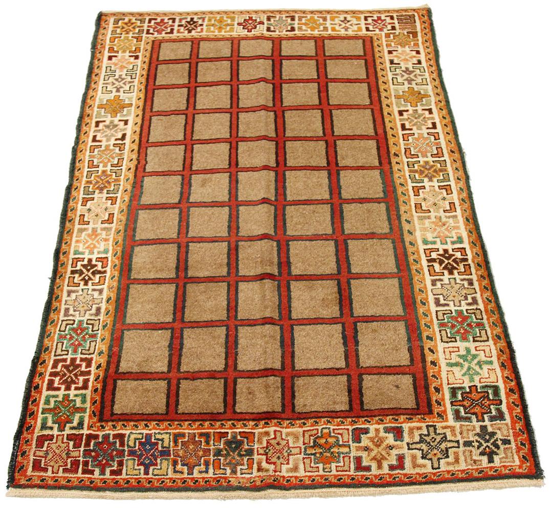 Antique Persian rug handwoven from the finest sheep’s wool and colored with all-natural vegetable dyes that are safe for humans and pets. It’s a traditional Shiraz design featuring beige square details over a red center field. It’s a lovely piece to