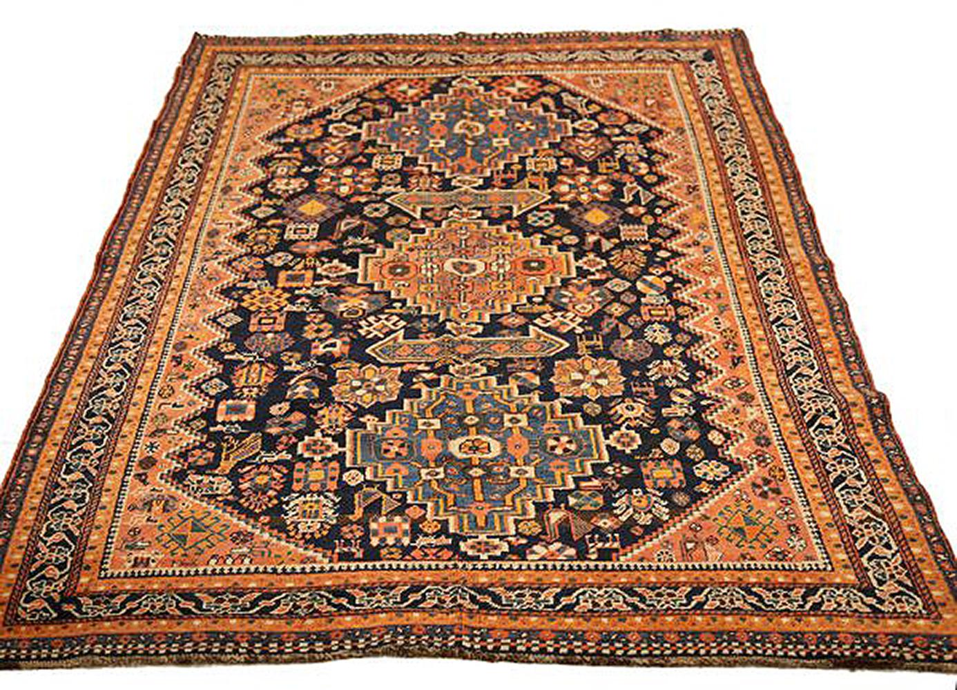 Antique Persian rug handwoven from the finest sheep’s wool and colored with all-natural vegetable dyes that are safe for humans and pets. It’s a traditional Shiraz design featuring blue, orange, and gray floral and geometric details over a black and