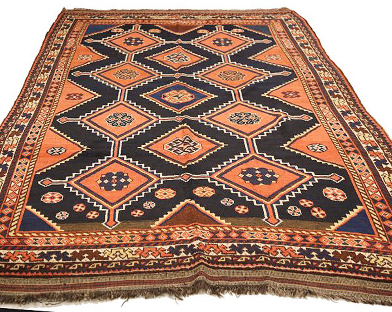 Antique Persian rug handwoven from the finest sheep’s wool and colored with all-natural vegetable dyes that are safe for humans and pets. It’s a traditional Shiraz design featuring blue, orange, and brown floral and geometric details over a black