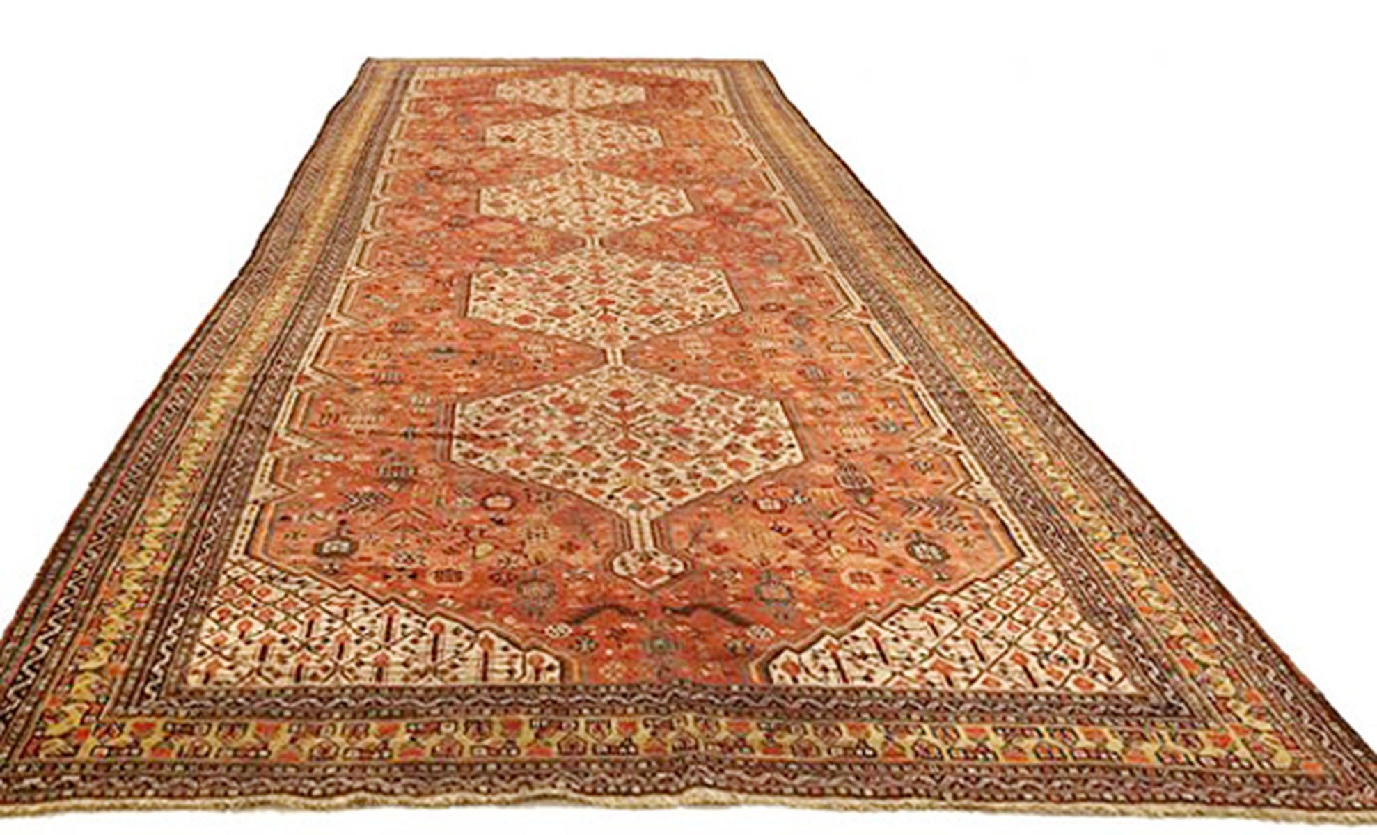 Antique Persian rug handwoven from the finest sheep’s wool and colored with all-natural vegetable dyes that are safe for humans and pets. It’s a traditional Shiraz design featuring green and brown floral medallions over a mix of black and navy
