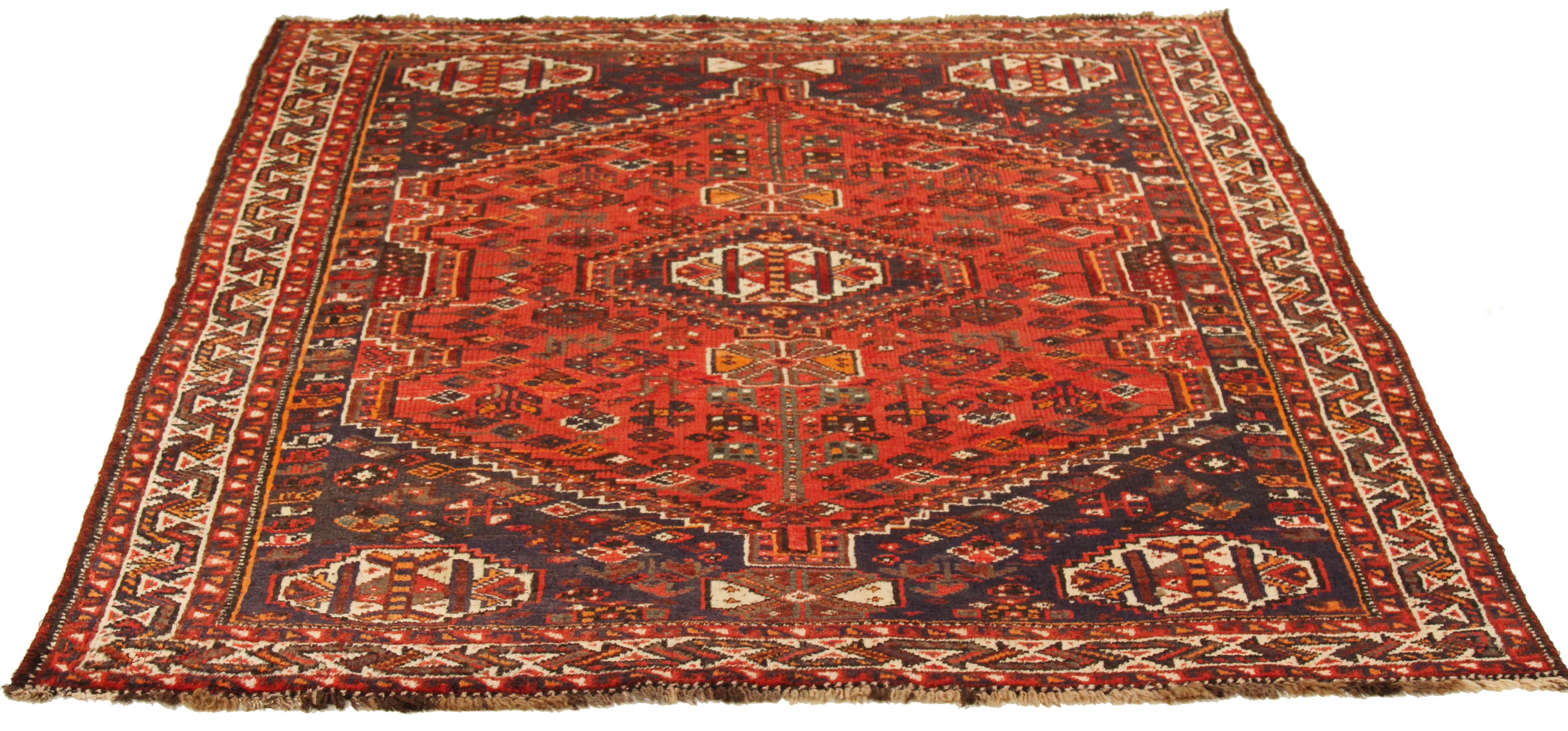 Antique Persian rug handwoven from the finest sheep’s wool and colored with all-natural vegetable dyes that are safe for humans and pets. It’s a traditional Shiraz design featuring red and white geometric details over a black and navy field. It’s a