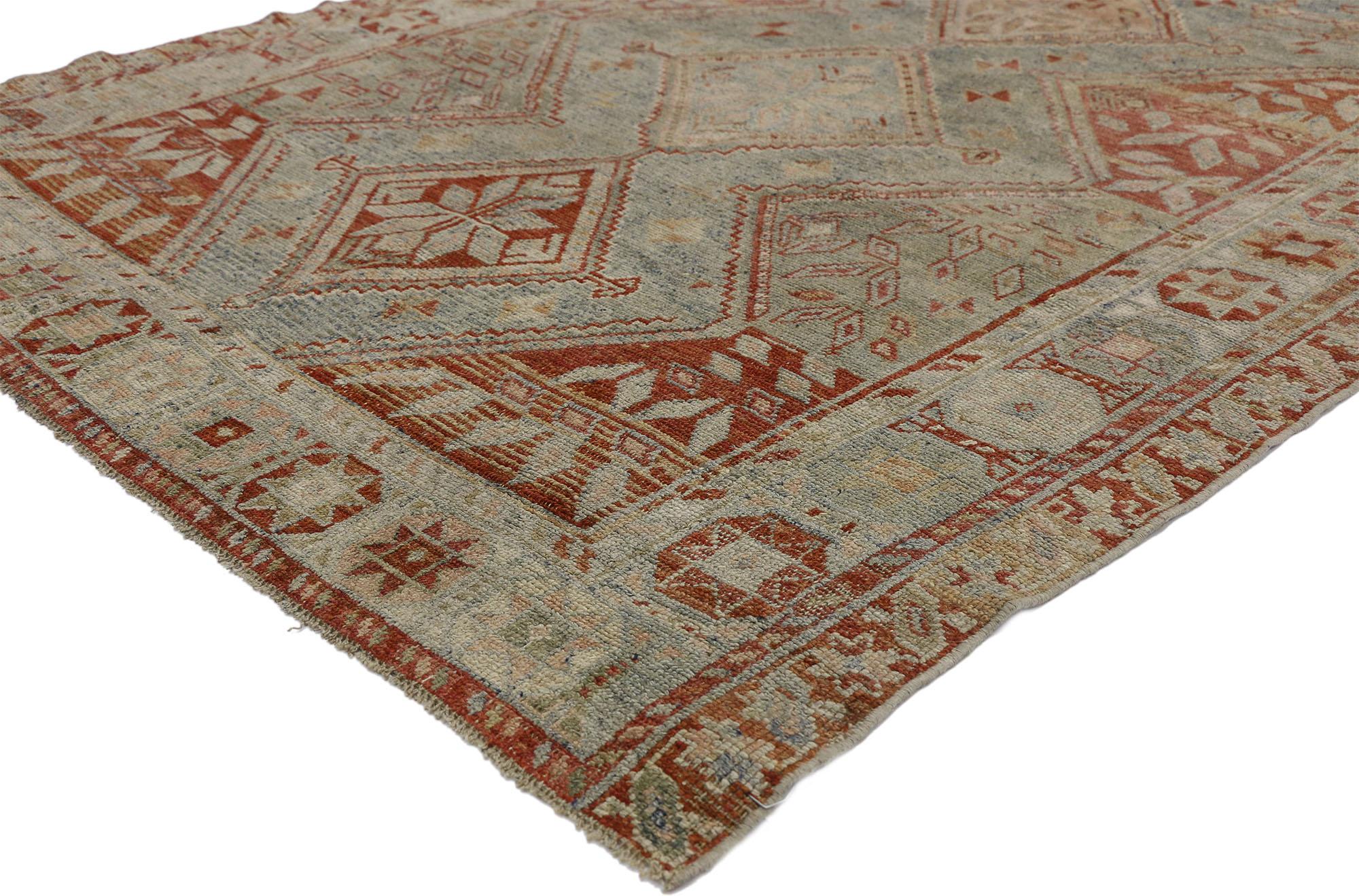 52455, antique Persian Shiraz rug with Subtle Bungalow style. This hand knotted wool antique Persian Shiraz rug features a subtly bungalow style with a diamond pattern in gradated, muted blues and bright red hues. A stacked pole medallion of