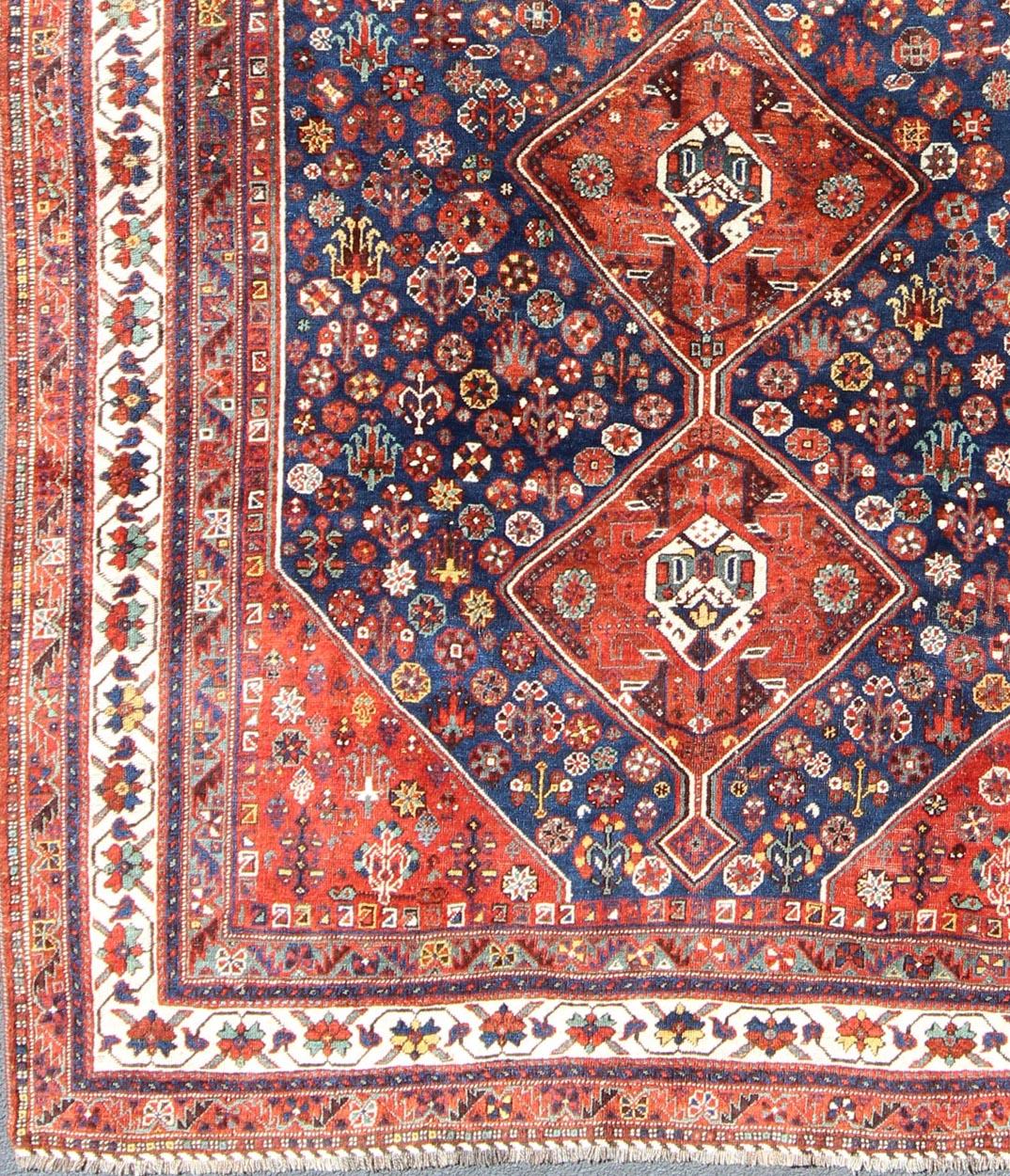 Persian Shiraz antique rug in red and blue with Medallion geometric design, rug ema-7567, country of origin / type: Iran / Shiraz, circa 1930.

This vintage Persian Shiraz rug (circa early 20th century) features a unique blend of colors and an