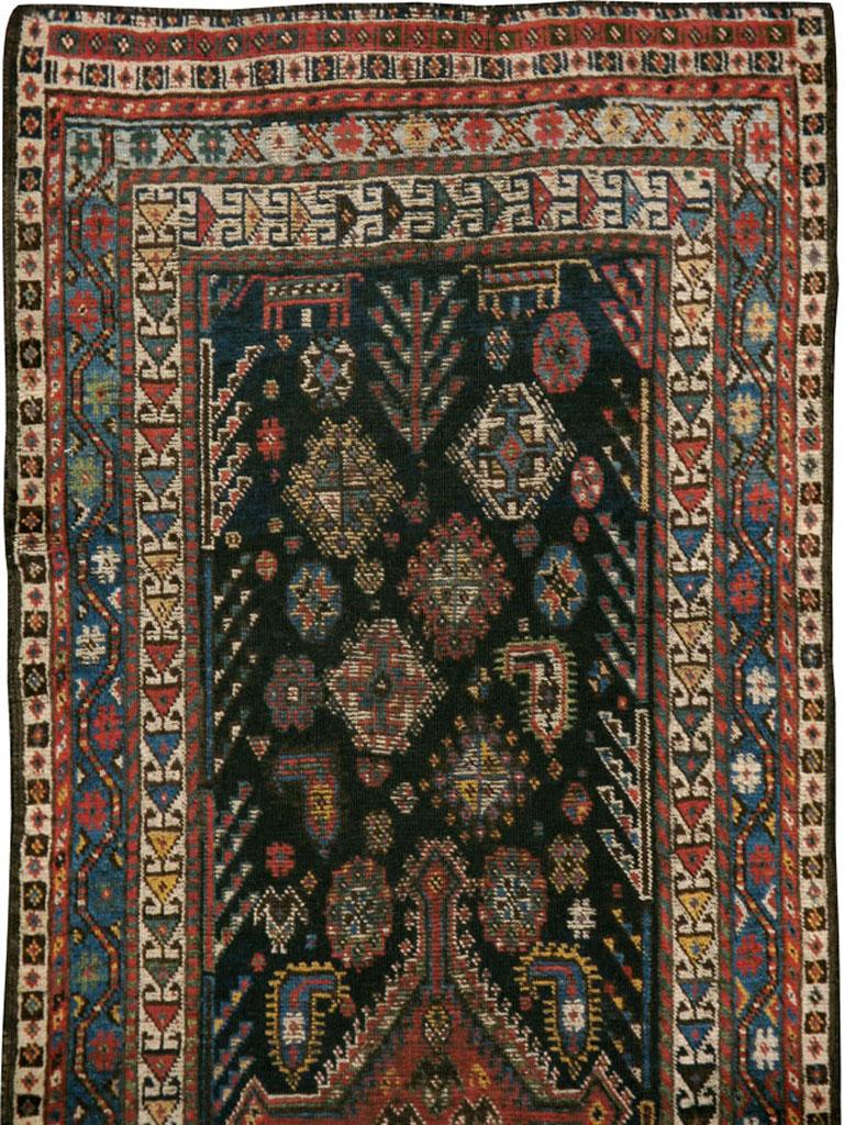 An antique Persian Shiraz rug from the early 20th century. From Fars Province in SW Persia, this tribal rug has a dark blue ground displaying botehs (paisleys), dogs, stars, lozenges, and feathery fronds, all around a red, comb-fringed lozenge