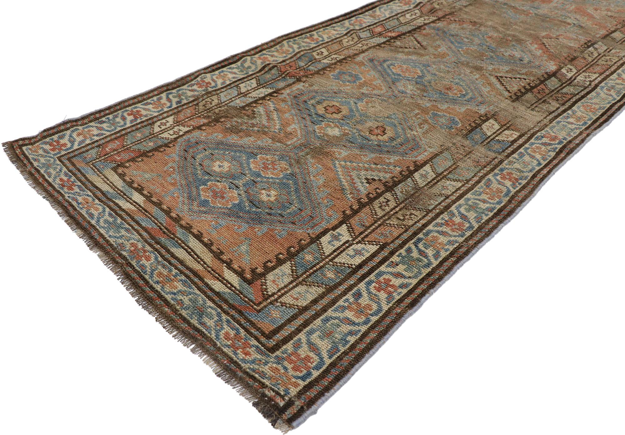 60890 distressed antique Persian Shiraz Runner 02'07 x 08'08. With its warm hues and rugged beauty, this hand-knotted wool antique Persian Shiraz runner will take on a curated lived-in look that feels timeless while imparting a sense of warmth and