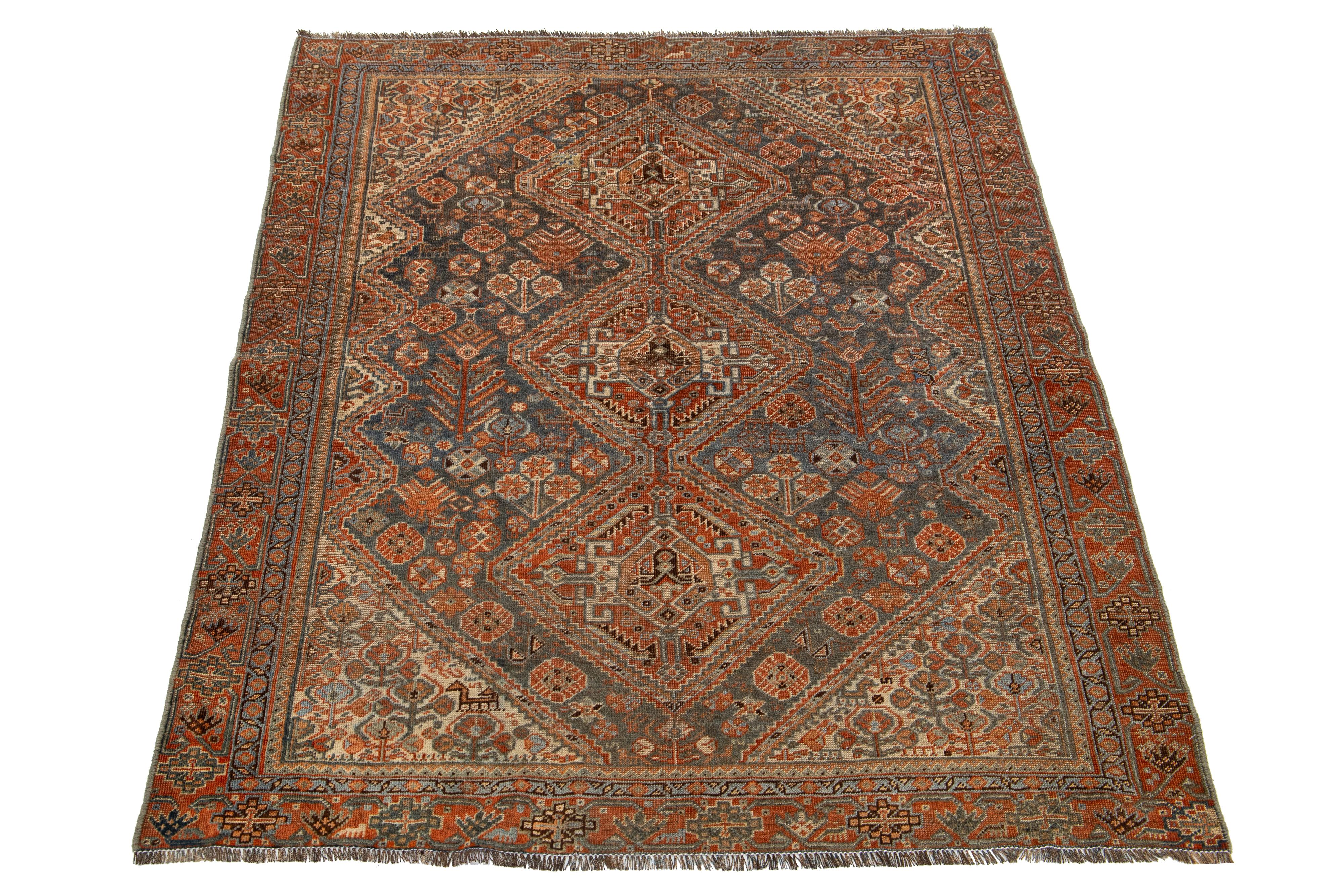 Dieser Teppich aus persischer Shiraz-Wolle zeigt ein Stammesmuster mit beeindruckenden Akzenten in Beige und Rost auf blauem Hintergrund.

Dieser Teppich misst 4'4