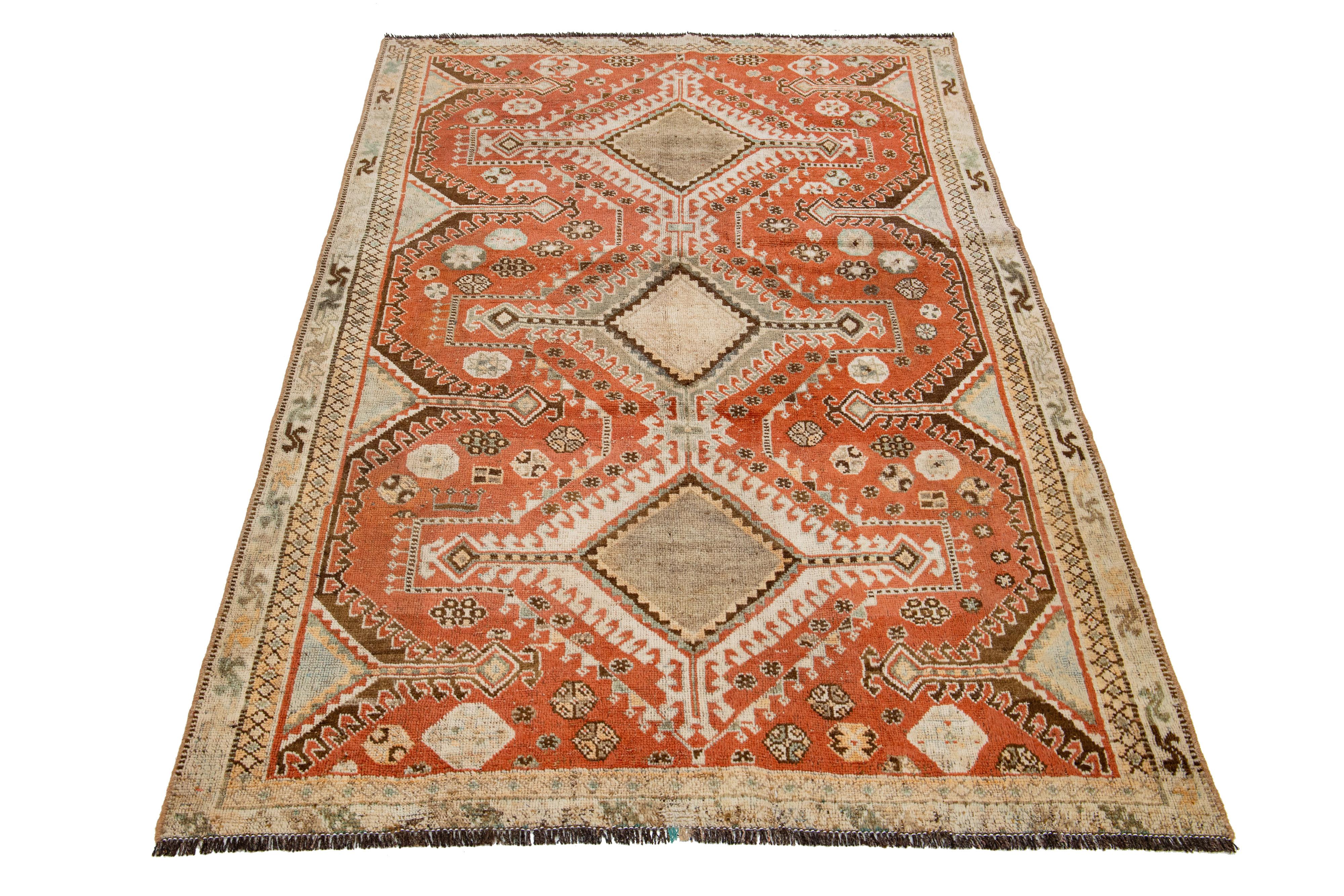 This Persian Shiraz wool rug displays a tribal design featuring stunning brown and beige accents on a rust background.

This rug measures 4'5