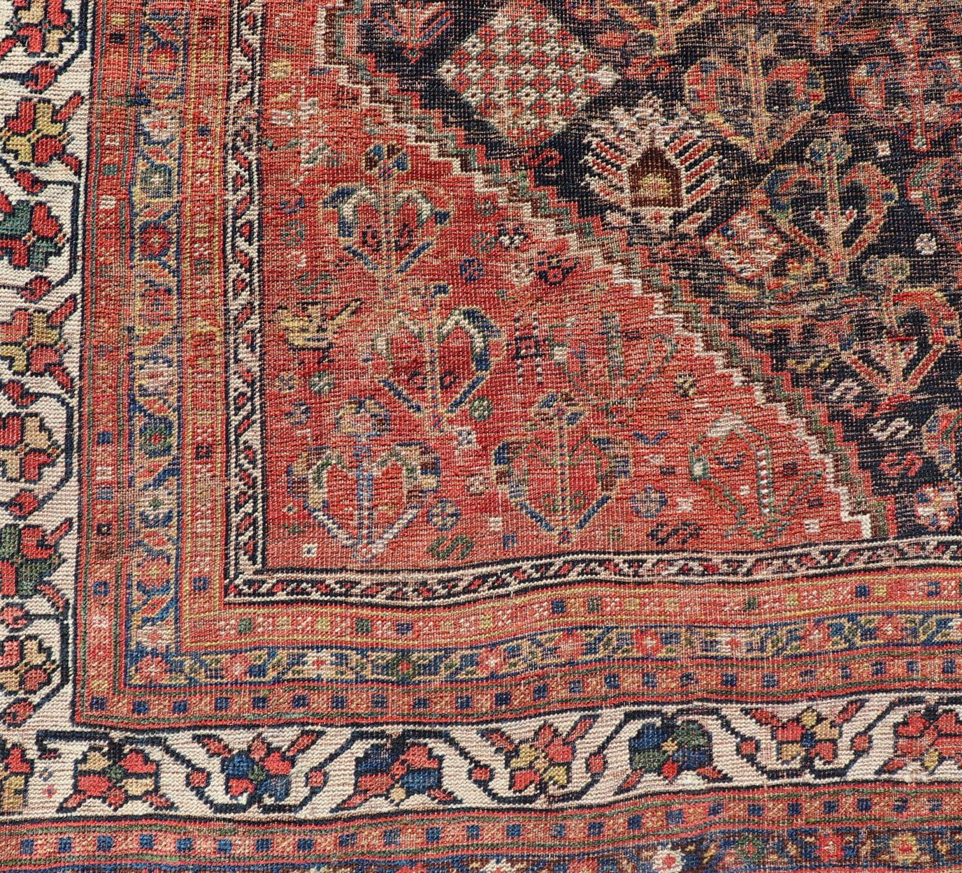 Mesures : 7'1 x 9'9 
Chiraz persan ancien à motif de médaillon sur toute la surface. Keivan Woven Arts ; tapis EMB-9703-13459, pays d'origine / type : Iran / Shiraz, vers 1910.

Cet ancien tapis tribal persan Shiraz a été noué à la main en laine et