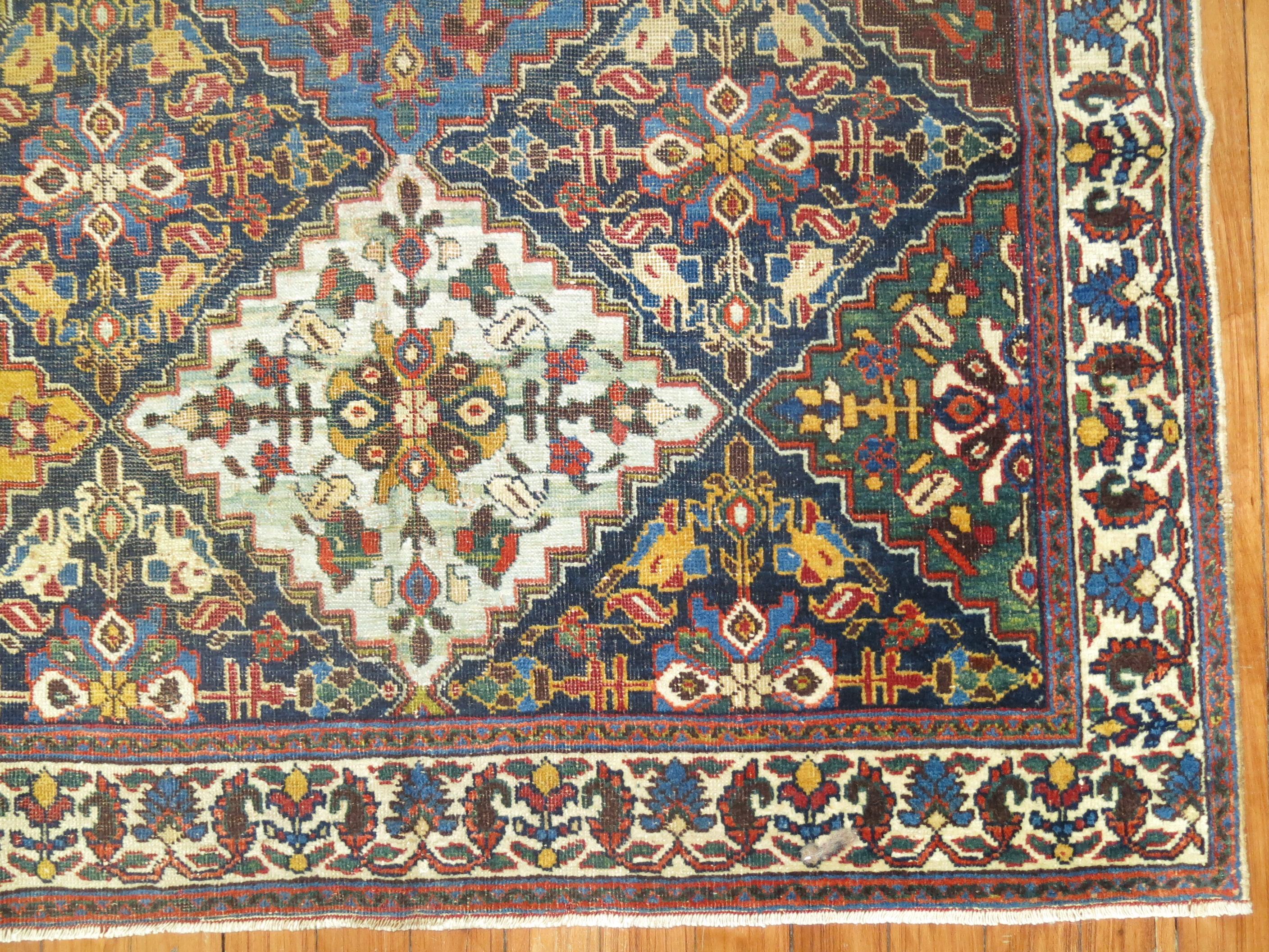 An early 20th century traditional small Persian rug with a large scale diamond shaped motif on a navy ground. Masculine and primitive. Some age natural wear. Measures: 3'4'' x 3'11''.

    