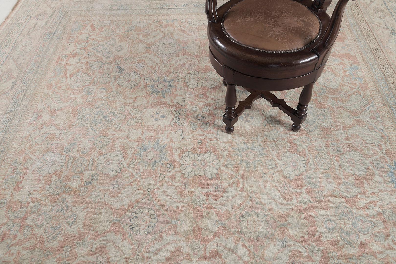Behold the antique Persian Sultanabad rug that is impeccably woven with all-over botanical patterns in the amazing tones of cinnamon, dustry blue and sand. This enchanting rug brilliantly expresses timeless elegance through its aesthetic garden