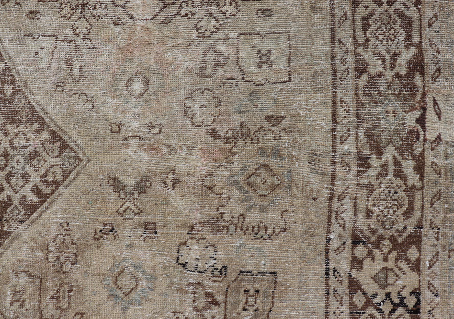 Measures: 9'10 x 13'8 

This antique Persian rug features an all-neutral palette of creams, taupe, and cocoas. The field homes a floral medallion and diamond casings. The corners of the field are brown. The cornices continue the design, beside the