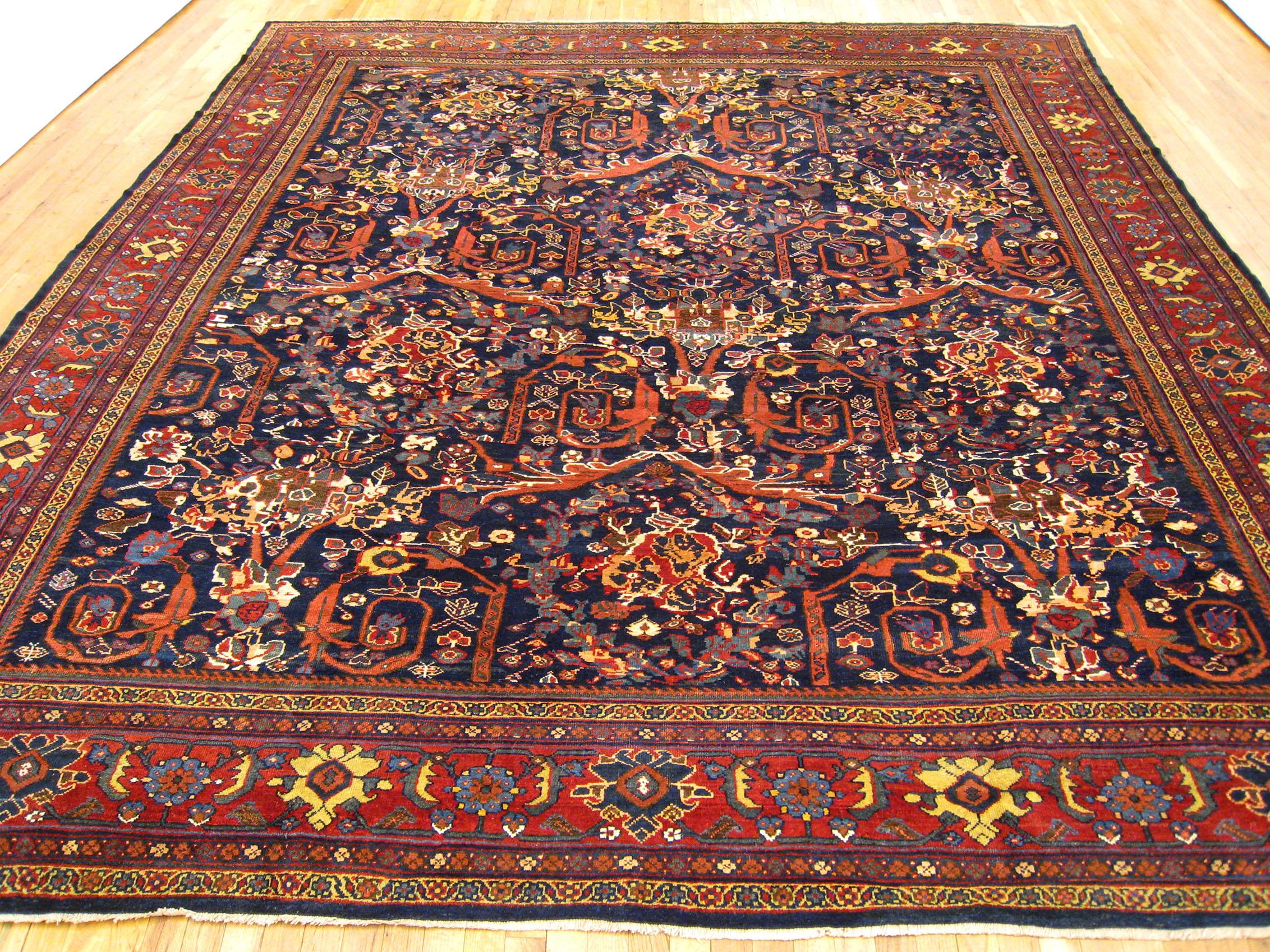 Antique Persian Sultanabad rug, room size, circa 1920

A one-of-a-kind antique Persian Sultanabad oriental carpet, hand-knotted with short wool pile. This lovely hand-knotted carpet features a mostophy design allover a navy primary field, with a