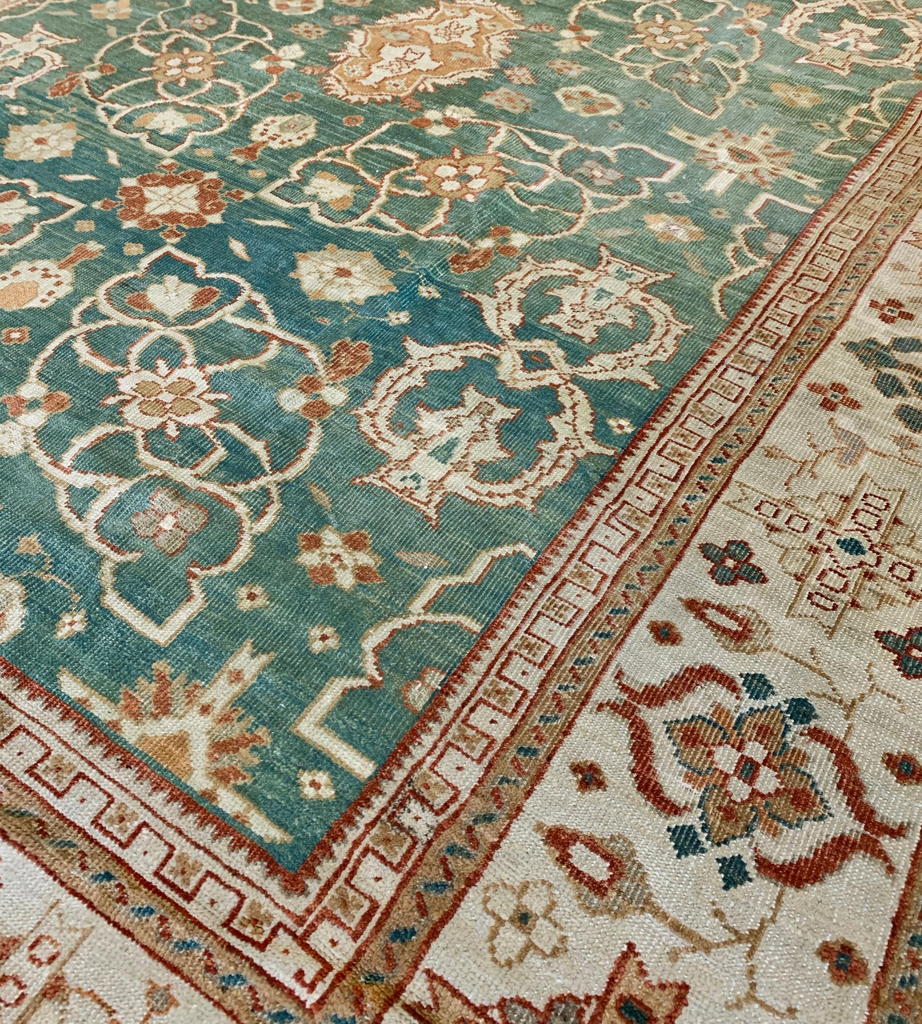 The shaded malachite field with a central column of brick-red and burnt-orange palmettes surrounded by ivory open floral cartouches, stylized linked vase motifs and minor further floral motifs, the broad ivory border with polychrome finely drawn