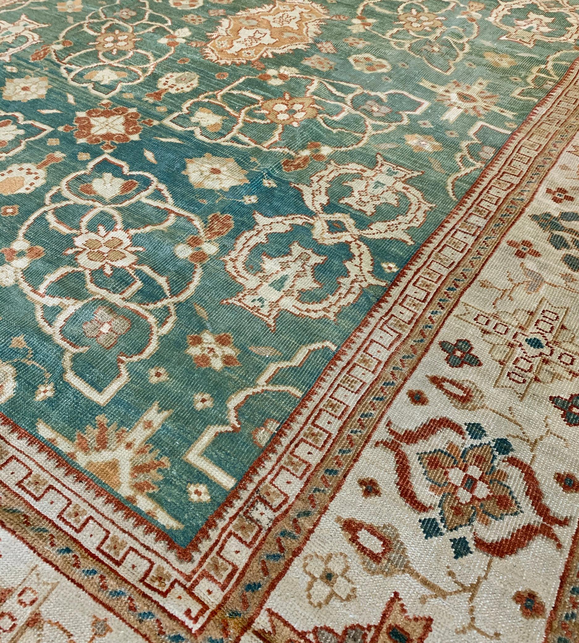 Le champ en malachite nuancée avec une colonne centrale de palmettes rouge brique et orange brûlé entourée de cartouches floraux ouverts en ivoire, de motifs de vase stylisés et d'autres motifs floraux mineurs, la large bordure en ivoire avec des
