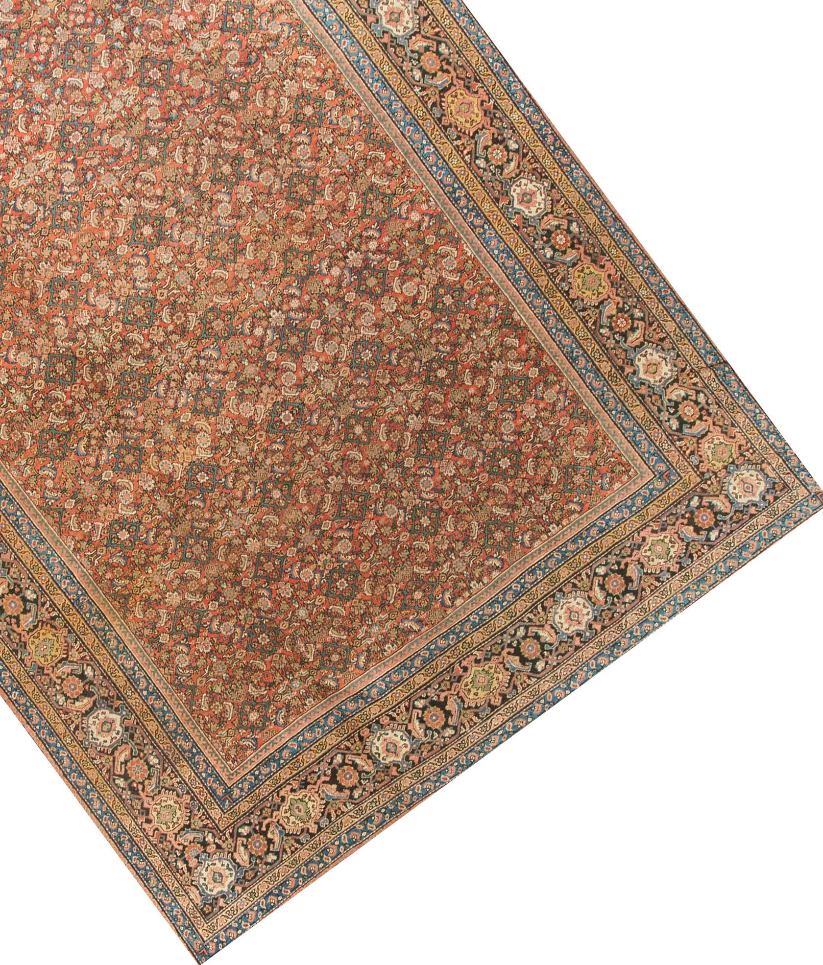 An antique Sultanabad rug with an all-over design on a red ground. The main border filled with beautiful flower heads surrounded by multiple guard borders in yellows light blues and rose.
