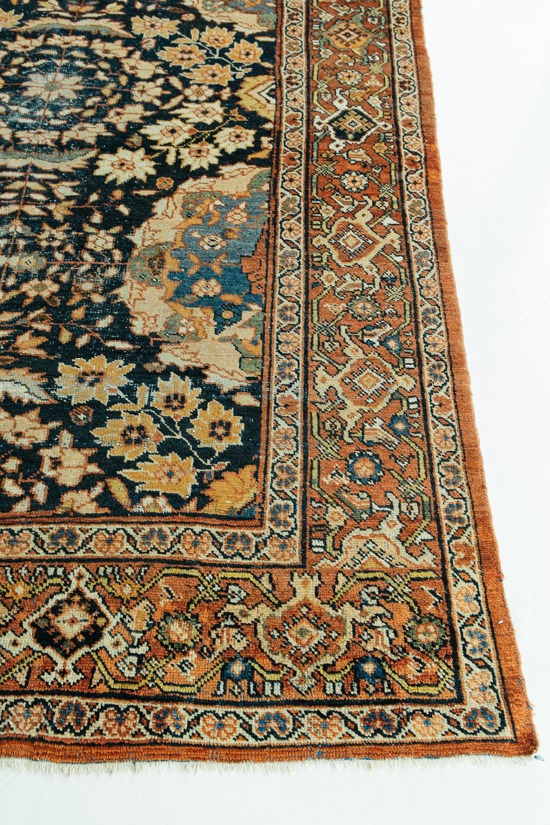 This stunning antique Sultanabad features an all-over design of alternating radial floral sprays and circular medallions against a midnight blue ground. Secondary colors include golden yellow, green, a range of blues, orange and tan. An intricate