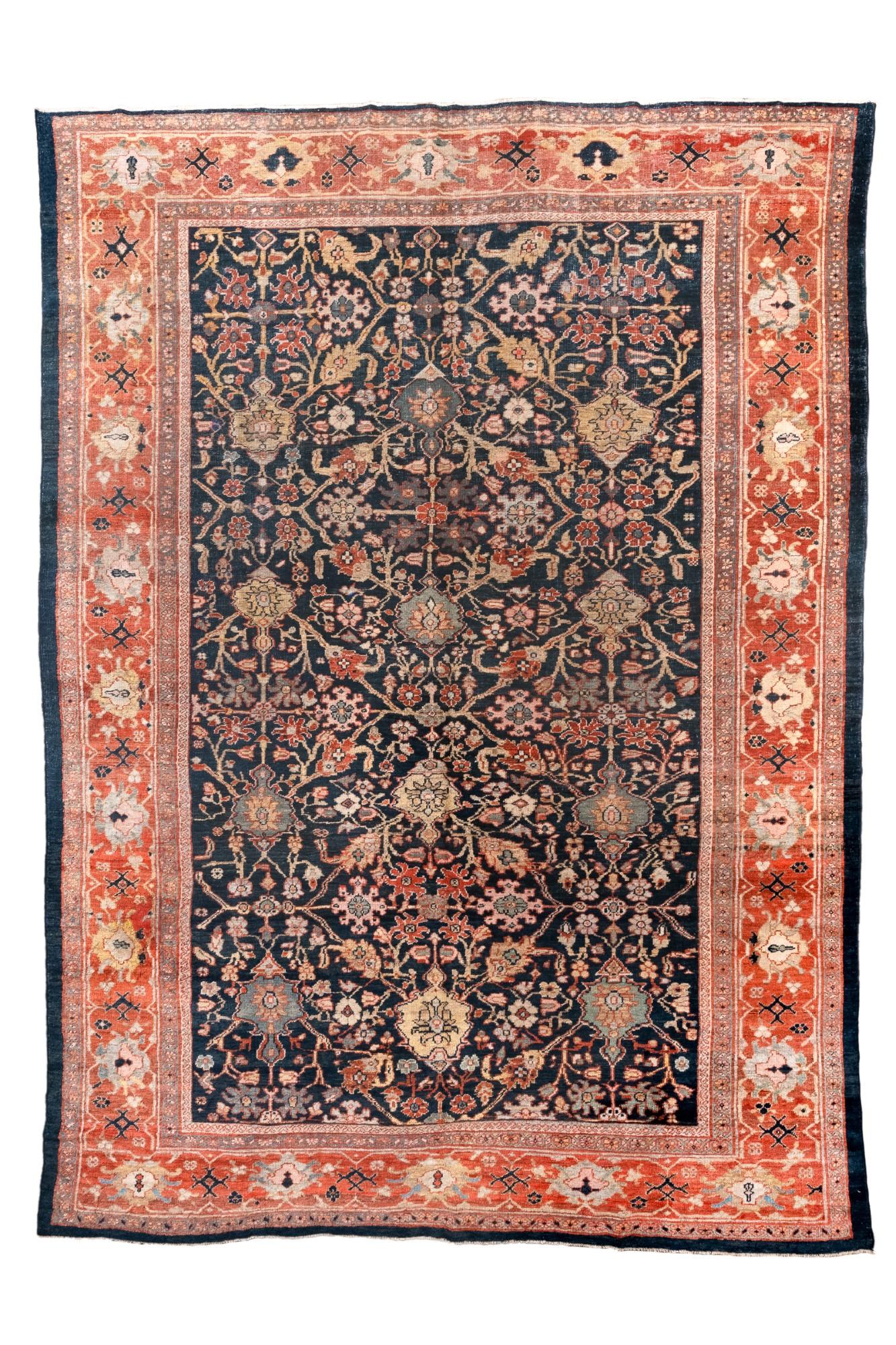 Questo grande tappeto persiano Sultanabad Rugs, tessuto intorno al 1900, presenta un'incredibile profondità.
campo indaco ornato da un disegno floreale allover. Rosso tenue, oro tenue e avorio
Gli accenti creano profondità ed eleganza, mentre