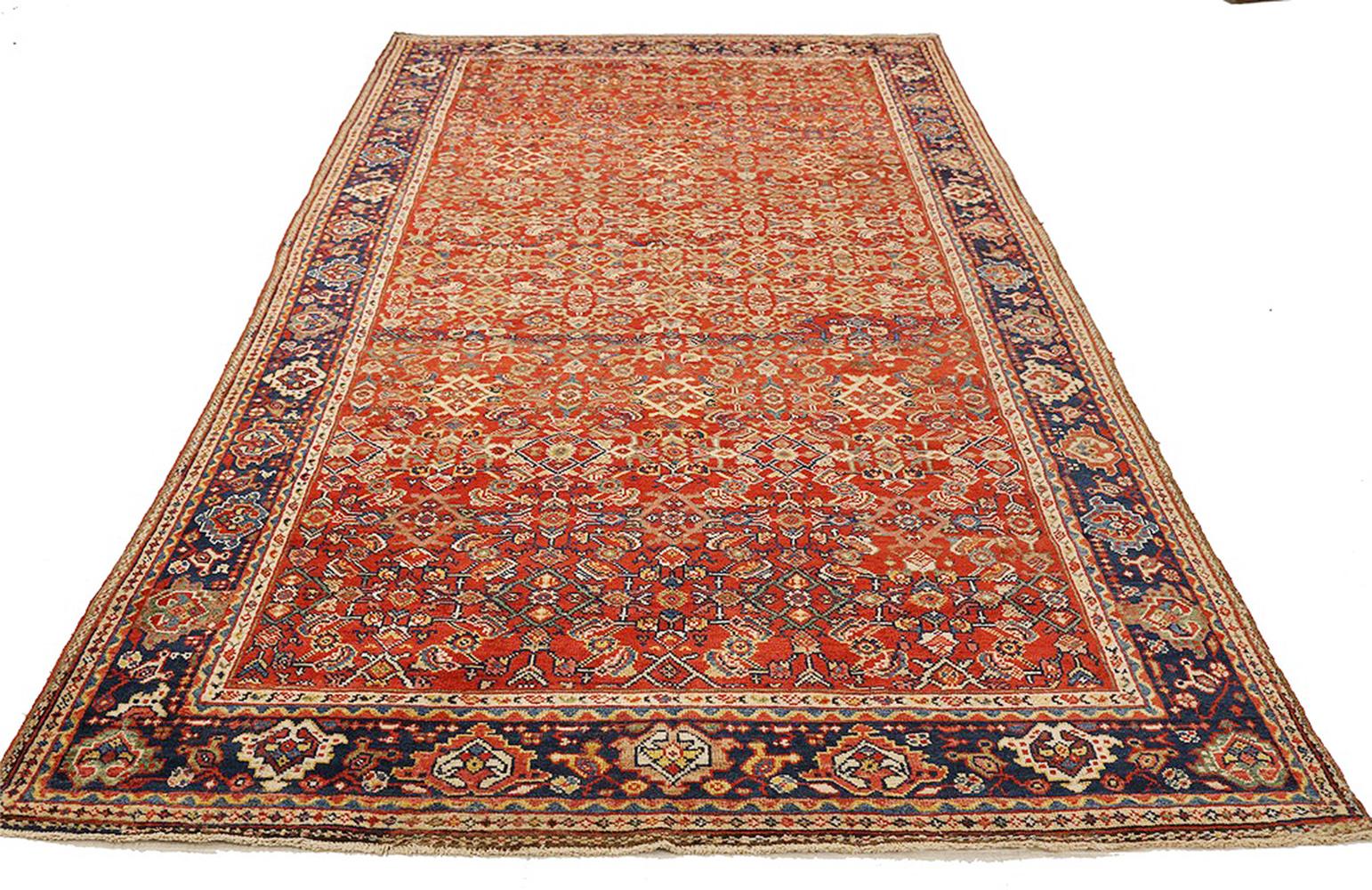 Antique handmade Persian area rug from high-quality sheep’s wool and colored with eco-friendly vegetable dyes that are proven safe for humans and pets alike. It’s a Classic Sultanabad design showcasing a regal red field with prominent green and