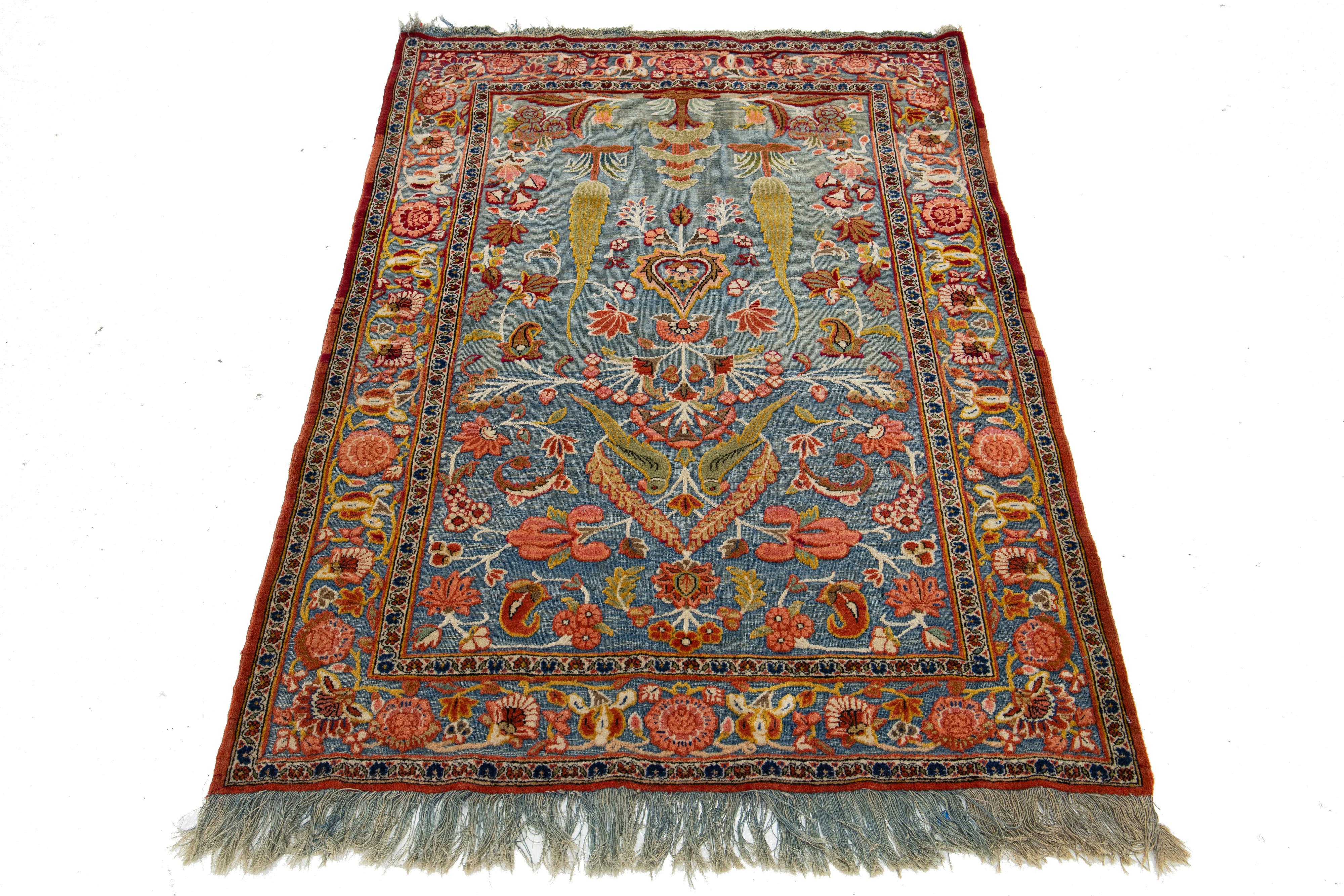 Ce tapis persan Tabriz des années 1920 présente un superbe champ bleu décoré de motifs floraux complexes, rehaussés de riches accents verts, pêches et rouges.

Ce tapis mesure 3'4