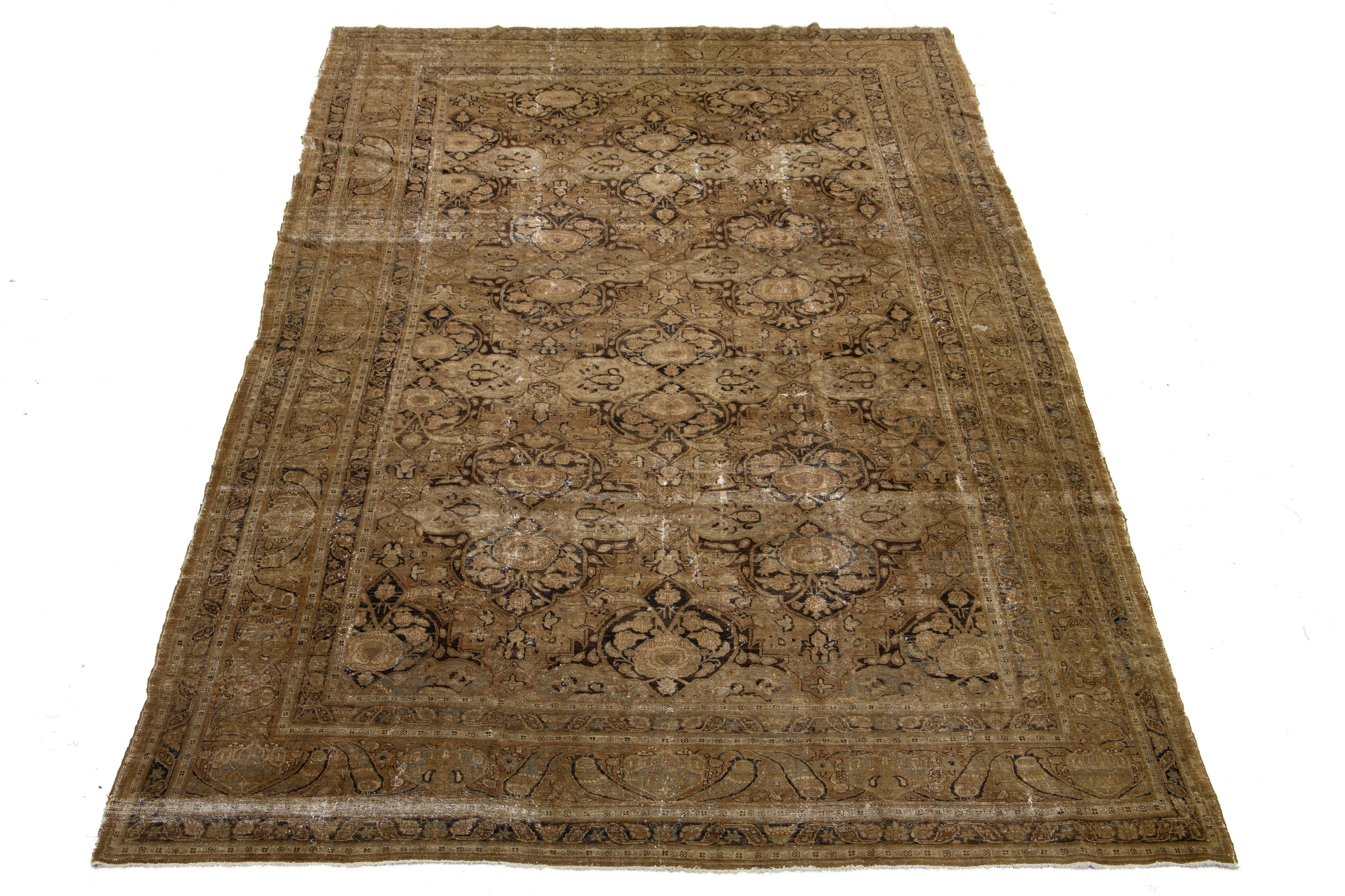 Entdecken Sie den Charme eines antiken Tabriz-Teppichs aus handgeknüpfter Wolle in Übergröße. Dieser Teppich zeichnet sich durch ein atemberaubendes Allover-Muster mit blauen und rostfarbenen Akzenten aus, das sich wunderschön vor einem warmen
