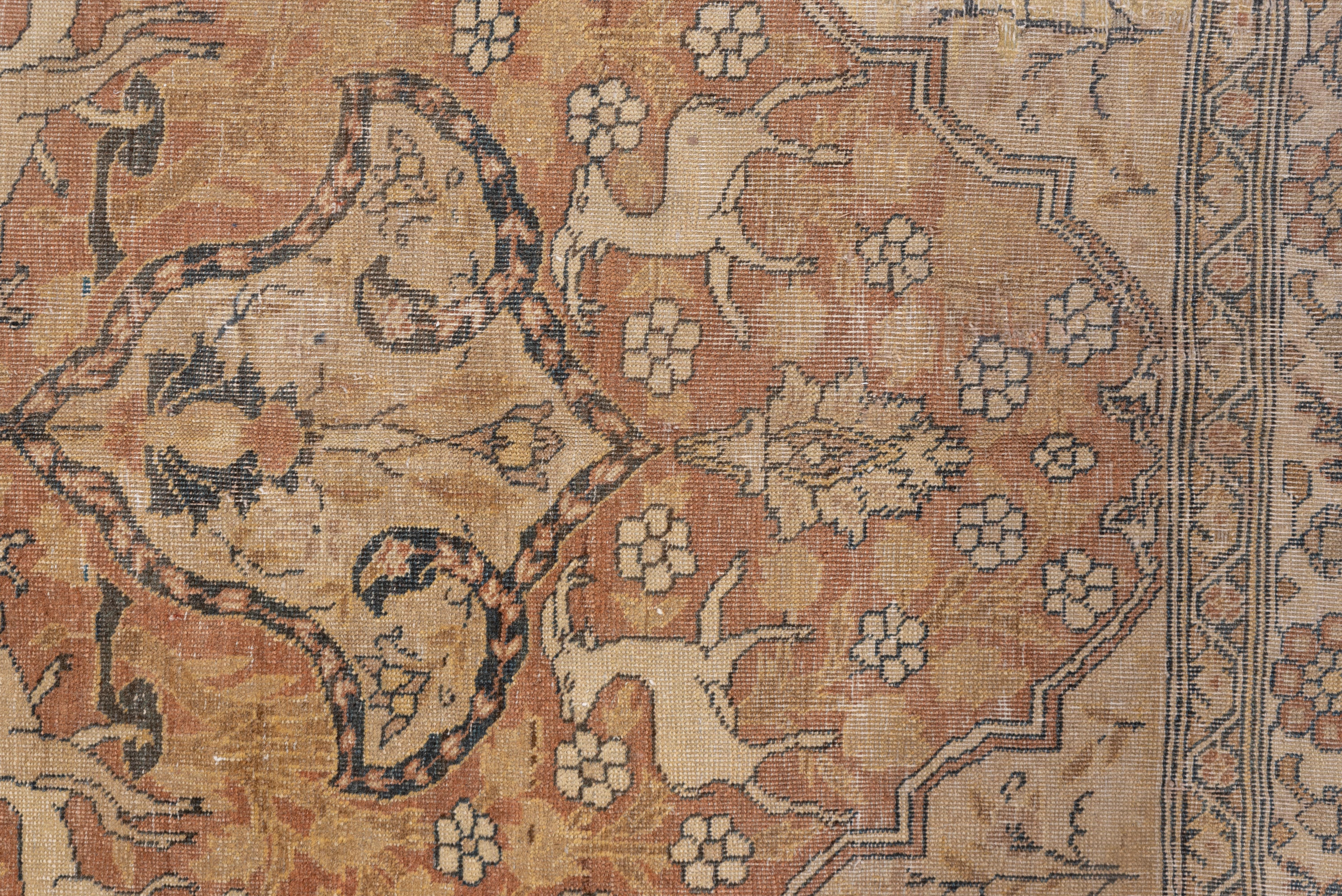 The buff-tan field shows numerous running animals including gazelles, lions and foxes, and the medallion and corners continue the theme. The ivory and taupe main border shows wide reciprocal lappets. Trees with red flowers grow in the four corners