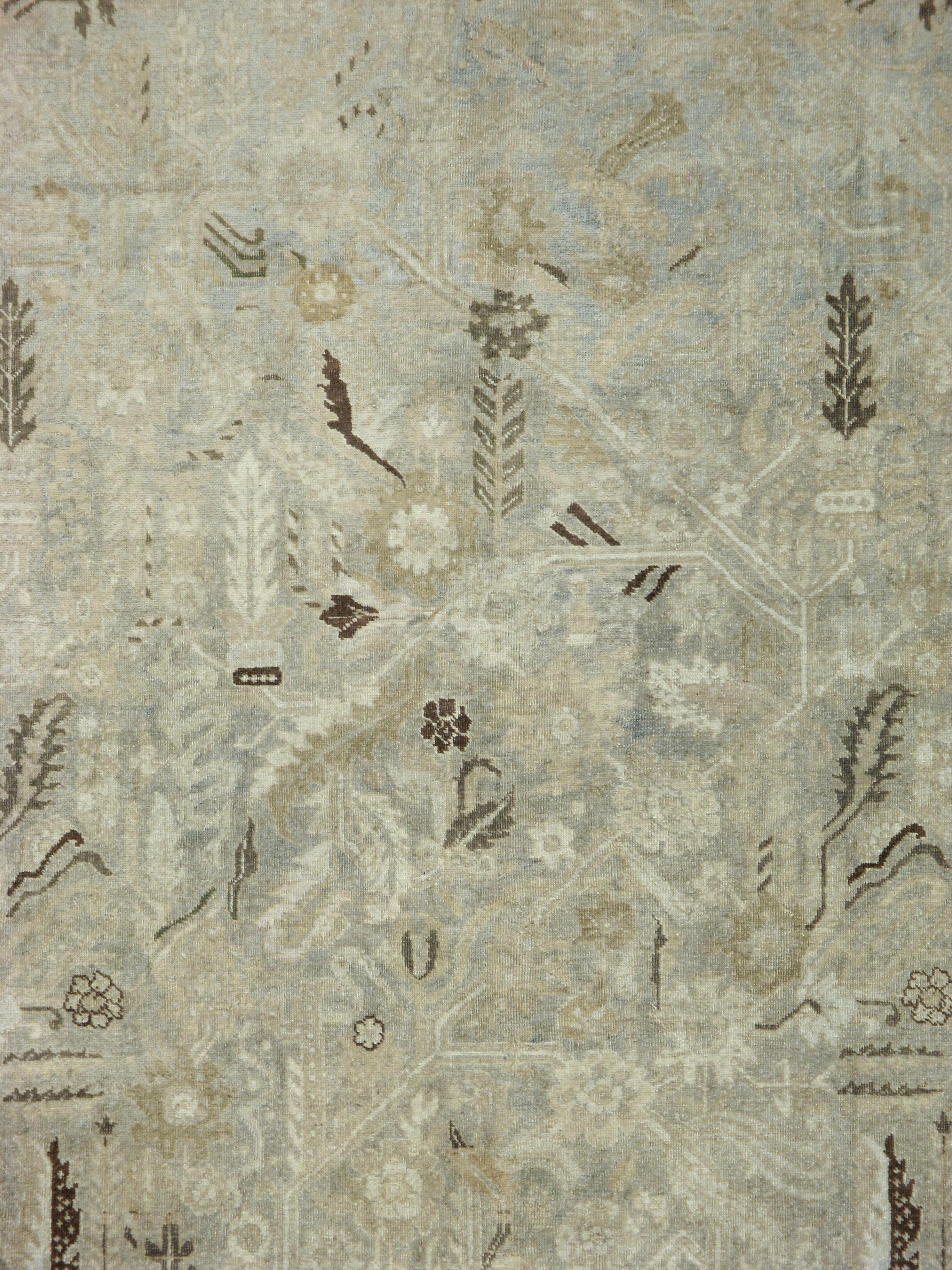An antique Persian Tabriz carpet from the early 20th century with a luster that yields a muted appeal.

Measures: 10' 11